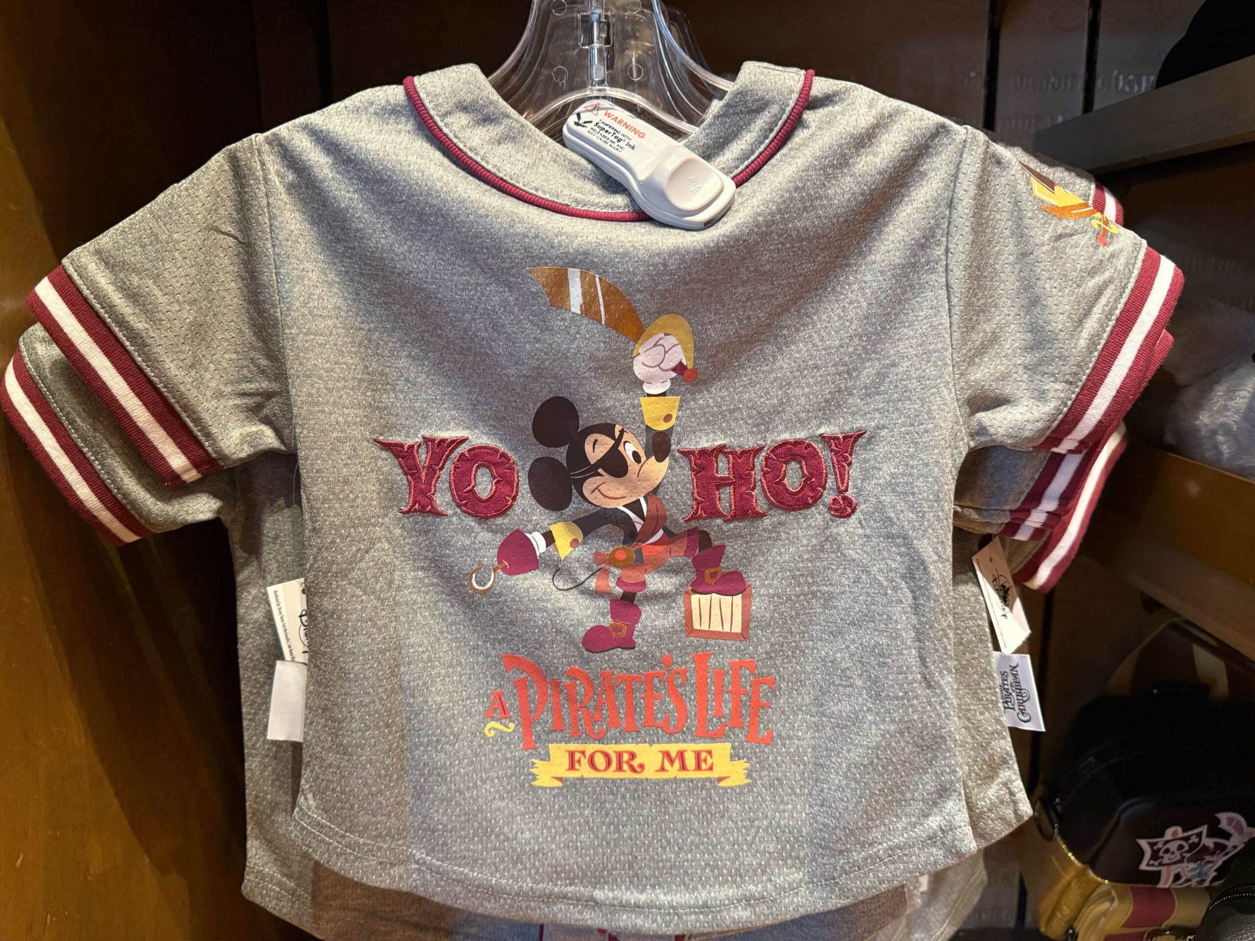 Gray t-shirt featuring Mickey Mouse as a pirate, holding a sword, with "Yo Ho! A Pirate's Life For Me"—a classic Disney Parks phrase.