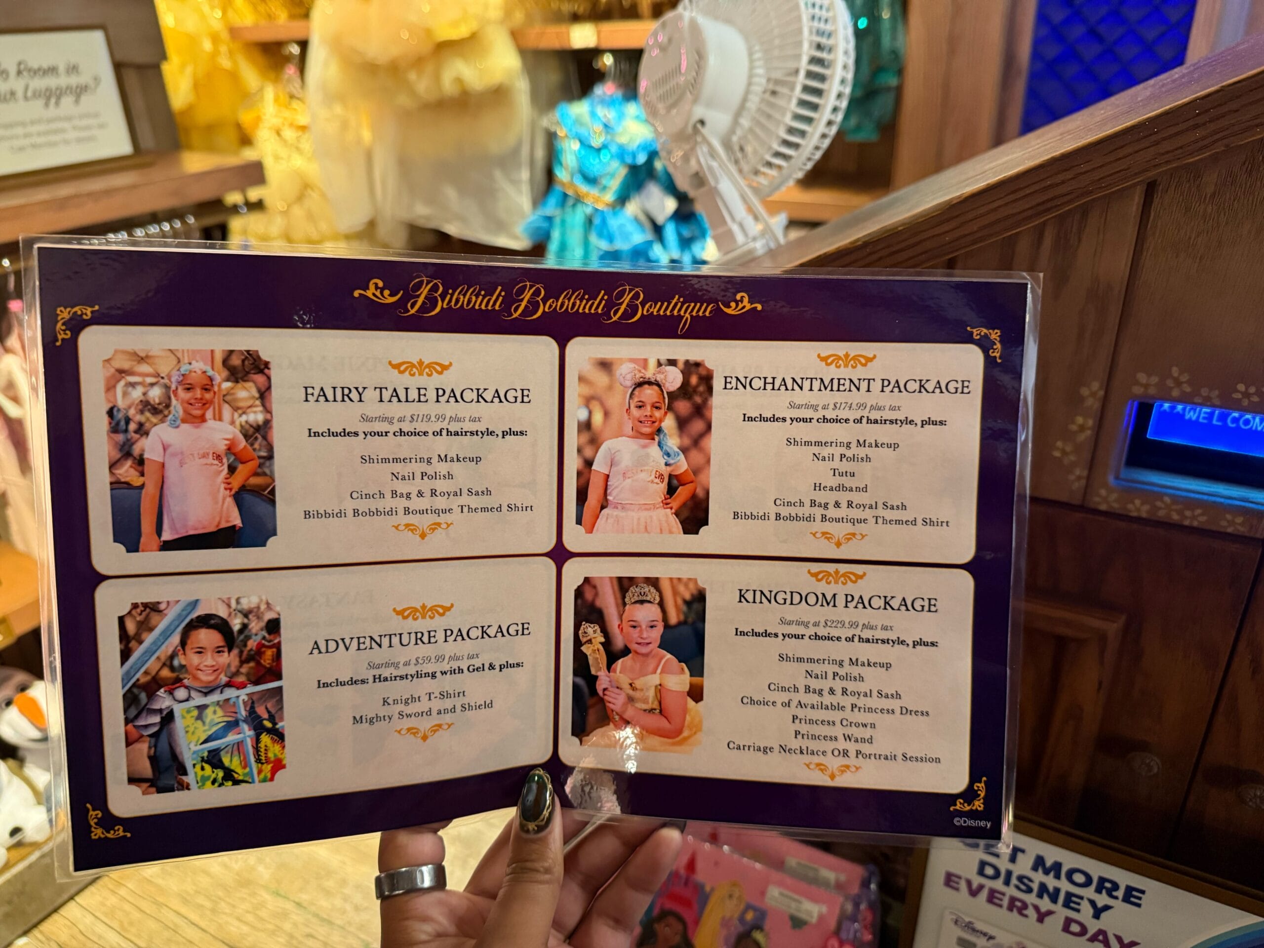 A Bibbidi Bobbidi Boutique menu at a Disney park shows four princess makeover packages for kids—just steps from the castle.