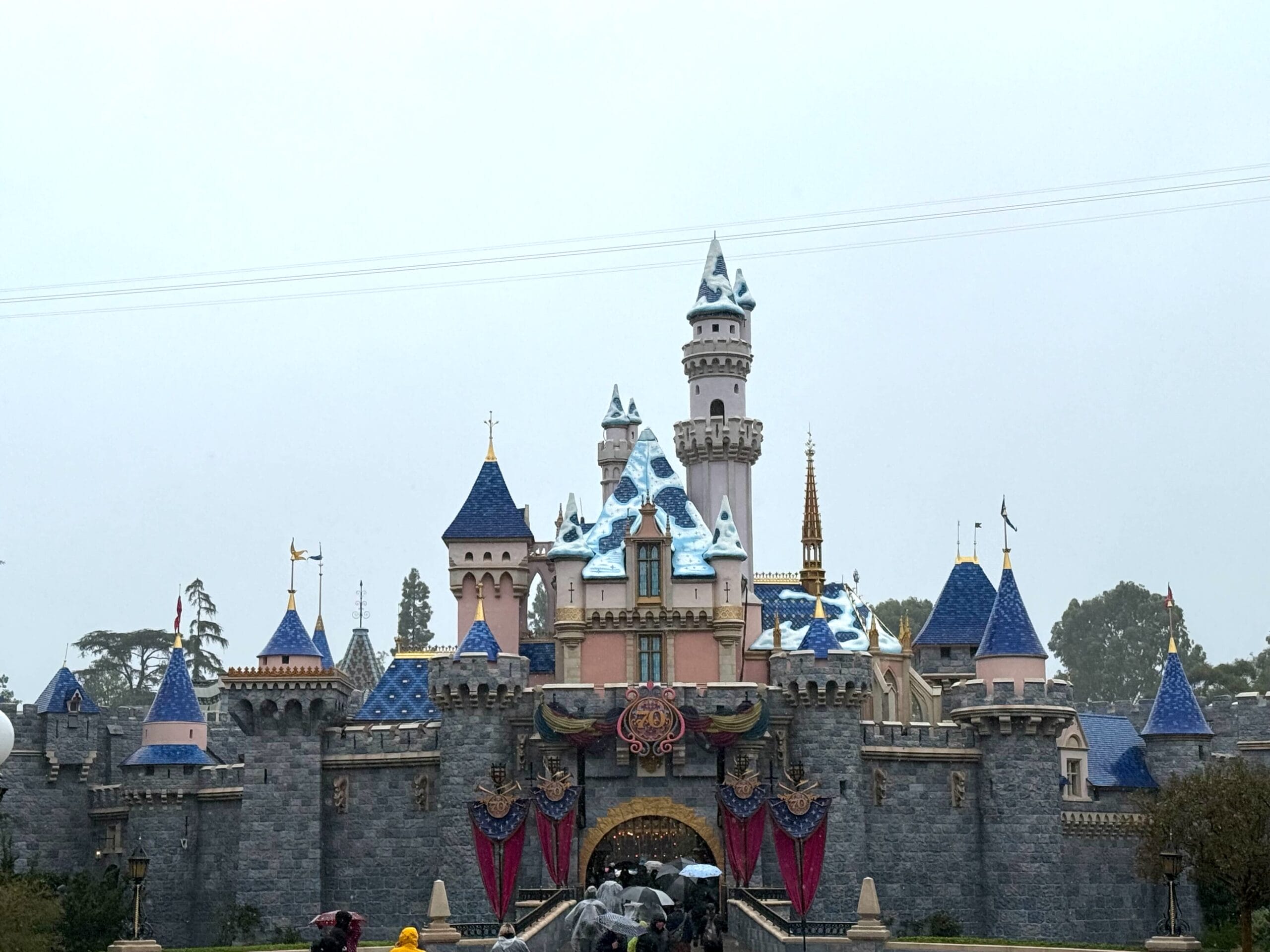 Sleeping Beauty Castle at Disneyland with blue and white rooftops, rare snow, smaller than Cinderella Castle at Walt Disney World.