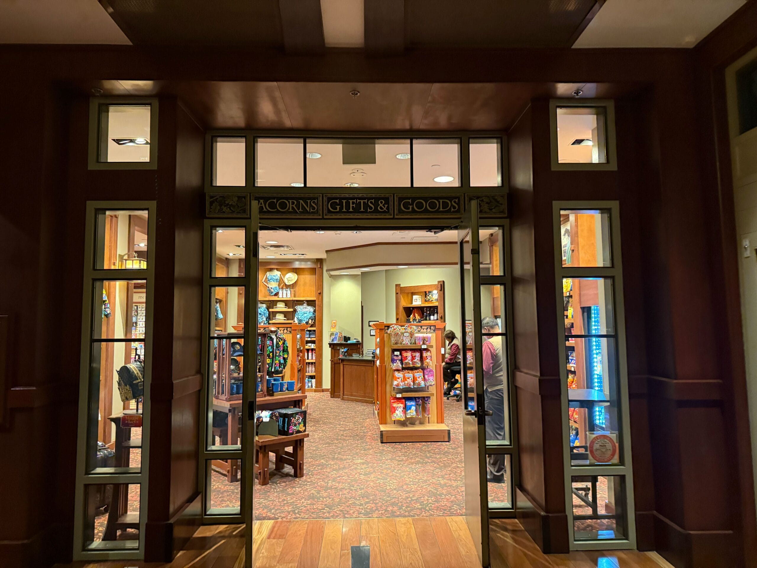 Glass doors open into a cozy Disneyland gift shop, stocked with park souvenirs and DVC exclusives