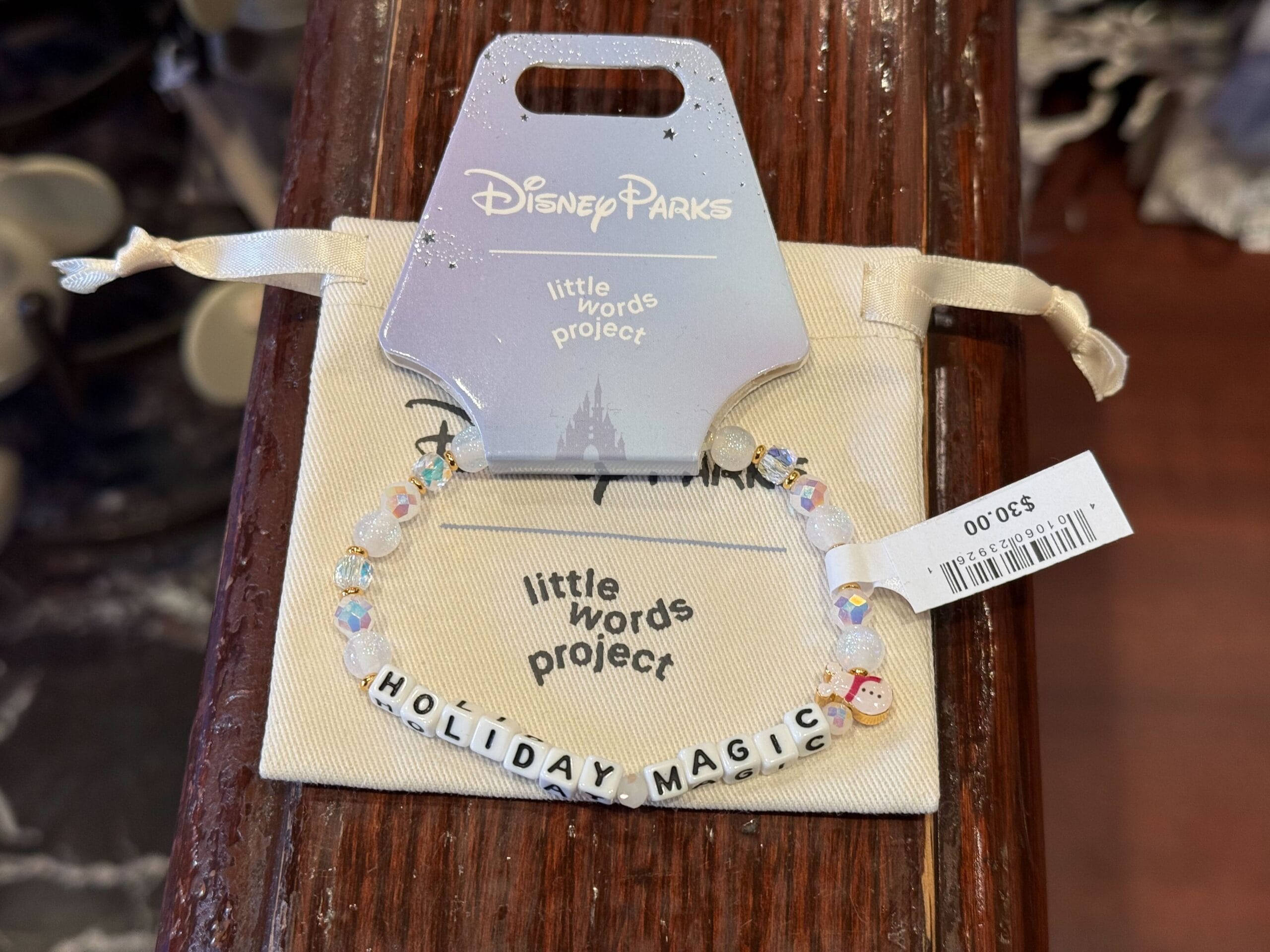 Beaded bracelet with "HOLIDAY MAGIC," Disney Parks tag, 2025 Disneyland Christmas merch, price tag visible—Disneyland style.