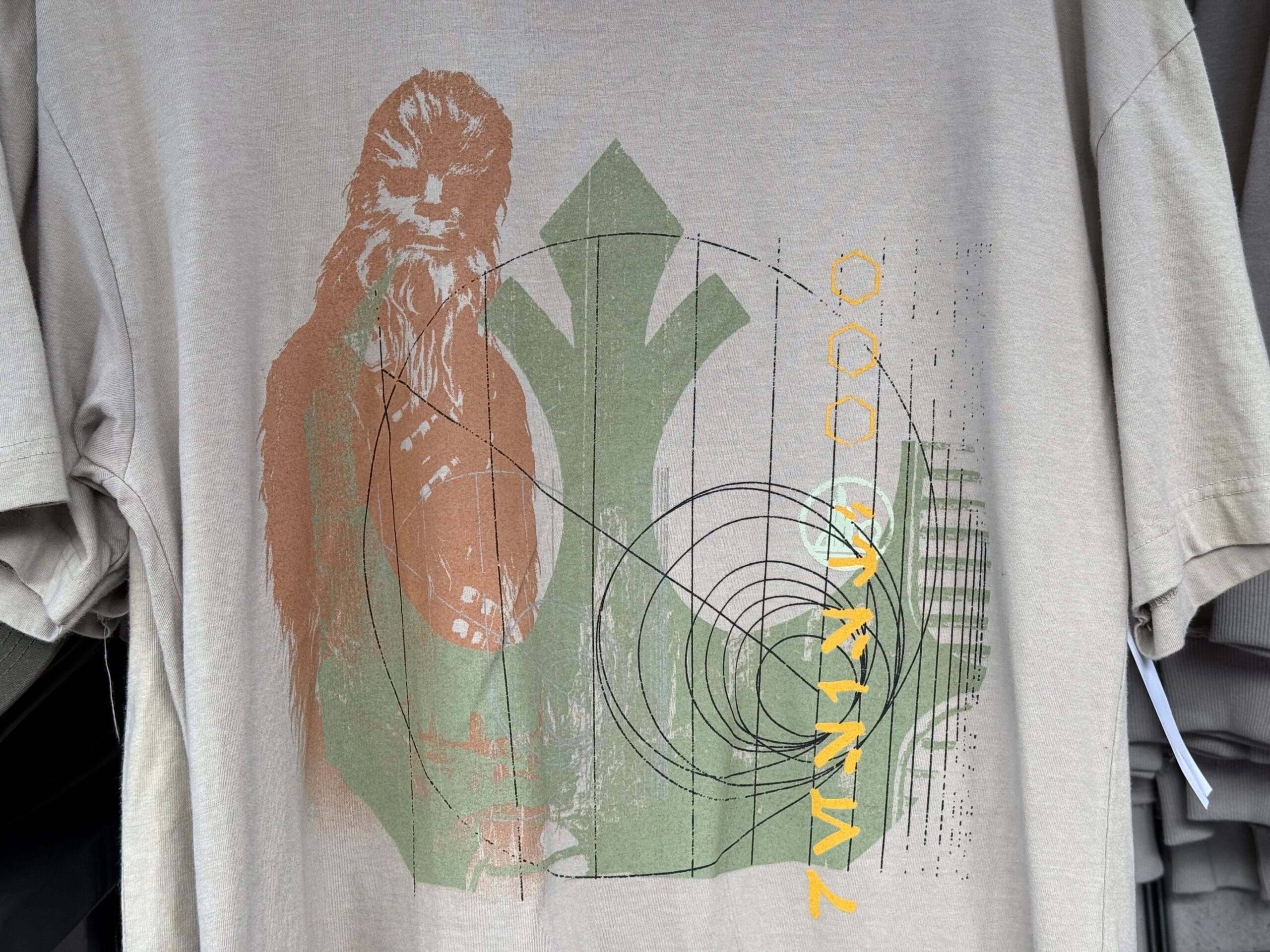 Beige t-shirt from Star Wars Galaxy's Edge at Disney Parks, with Chewbacca and a green Rebel Alliance symbol—Resistance gear.