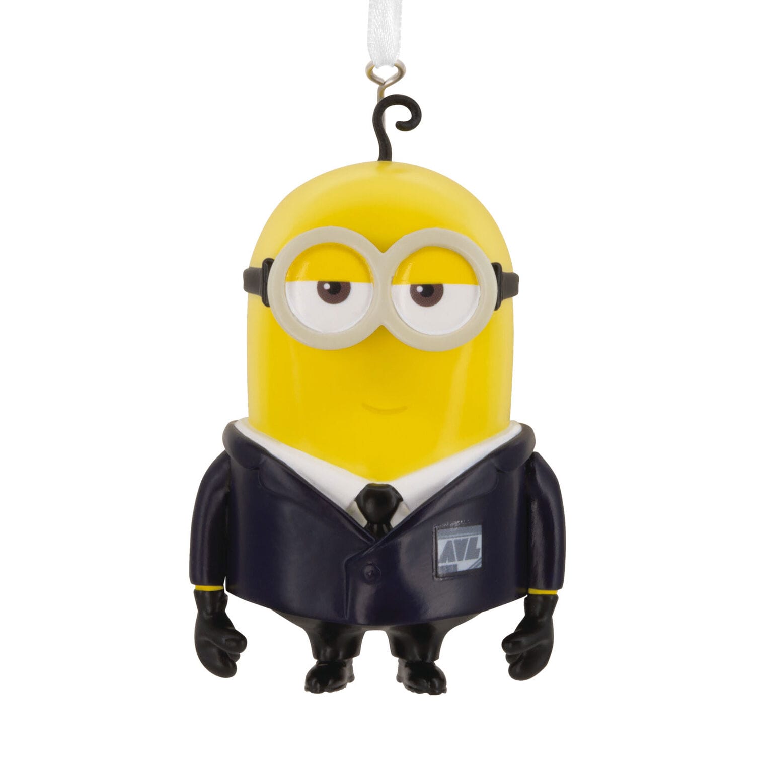 A yellow minion ornament, dressed in a black suit and goggles, hangs by a white ribbon