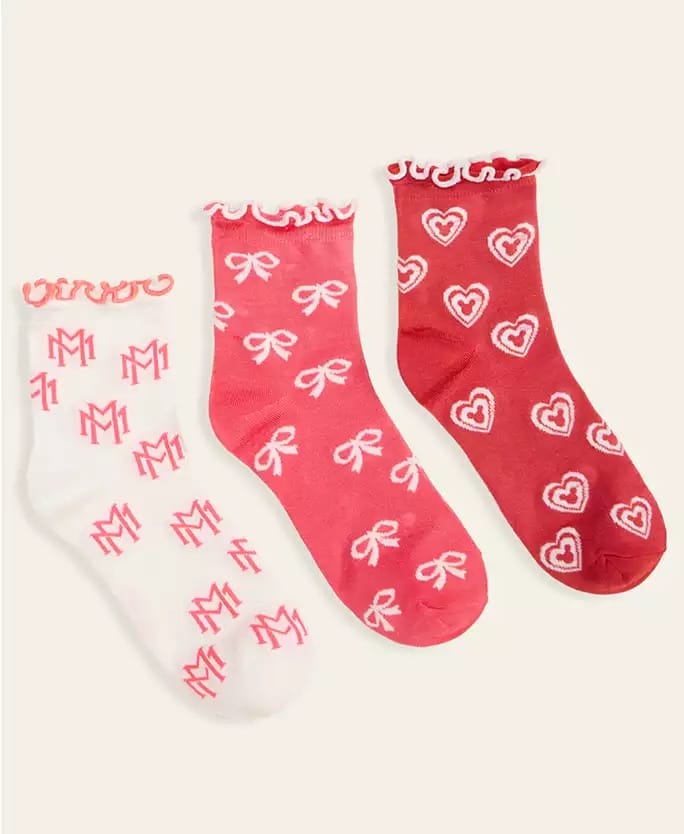 Three pairs of frilly ankle socks from Macy's, each with Disney-inspired flair: white with pink monograms, pink bows, and red hearts.