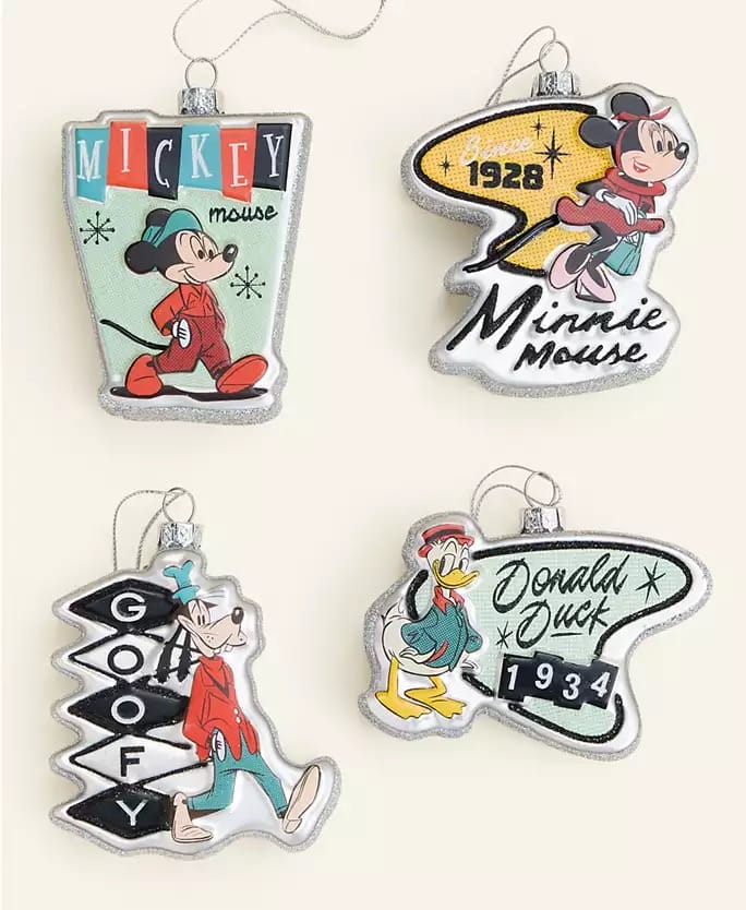 Four Disney Christmas ornaments with retro designs and years, resembling park souvenirs from Macy's 2025 Holiday Collection.
