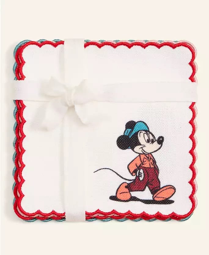 Square white napkin with red and blue trim, Disney cartoon mouse, tied in a white ribbon bow. Reminiscent of Disney Parks style.