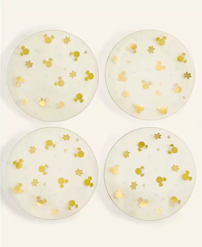 Four round coasters with gold Mickey Mouse heads from the Disney Holiday Collection 2025, inspired by park-exclusive designs.