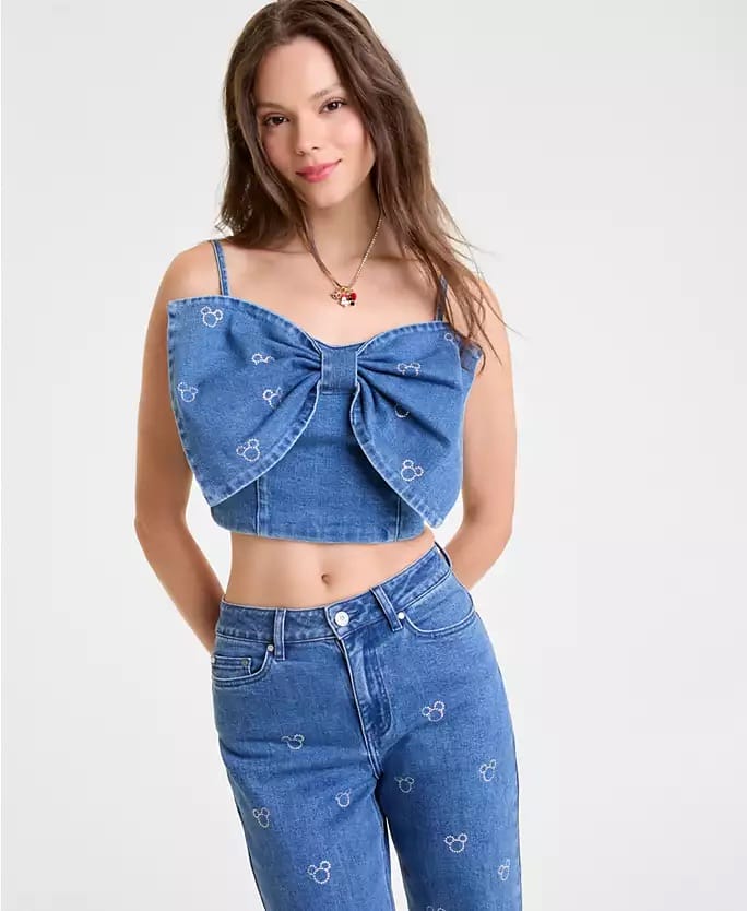 Woman in a blue Disney denim crop top with bow and Mickey jeans, similar to styles seen at Disneyland parks, Macy's Holiday Collection.