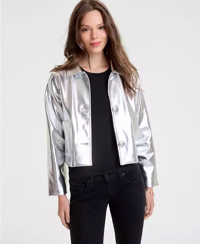 Woman in a shiny silver jacket and black pants, styled for Macy's 2025 Holiday Collection, posed as if visiting a Disney park.