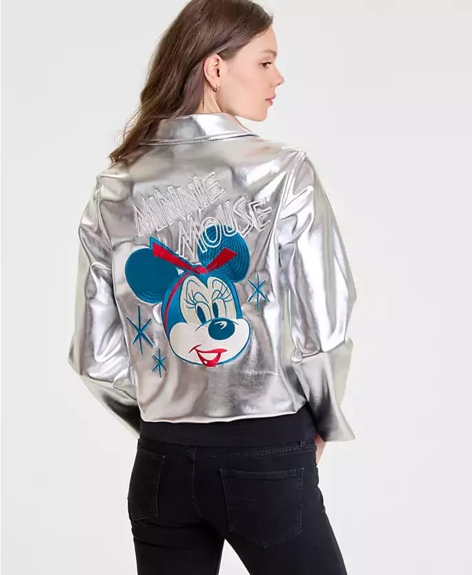 Woman in a silver Disney jacket with a bold Minnie Mouse graphic, black jeans; style fits right in at any Disneyland park worldwide.