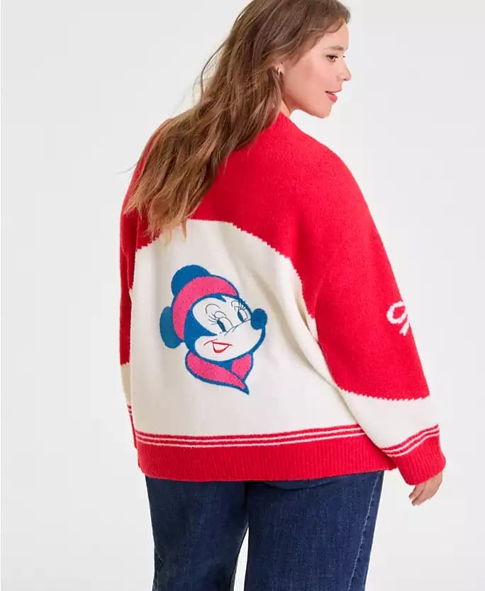 Woman in a Disney red and white sweater with Mickey Mouse on the back, standing sideways at a Disney park, no castle visible.