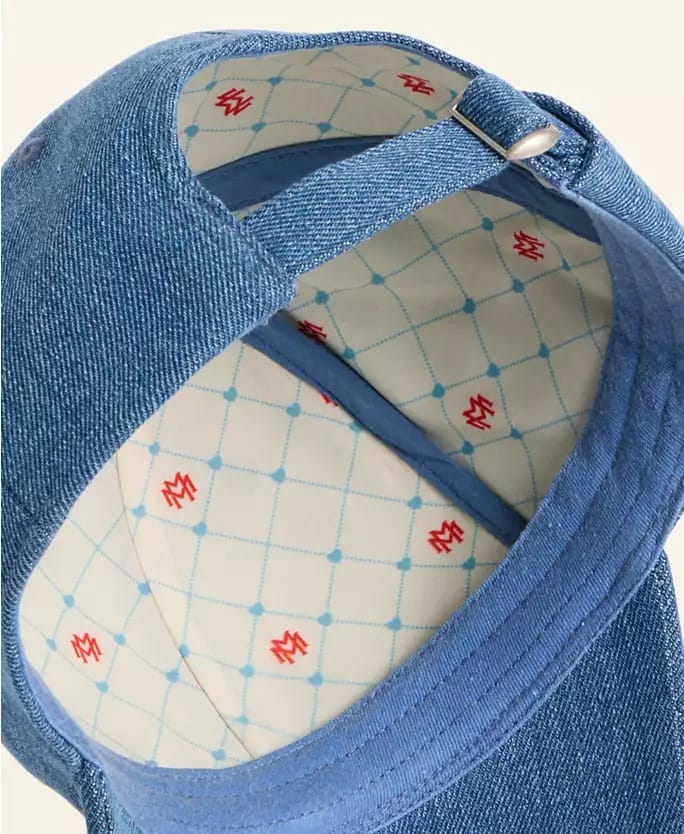 Close-up of a blue denim cap with white patterned lining, reminiscent of trendy hats sold in Disney Parks during holiday seasons.