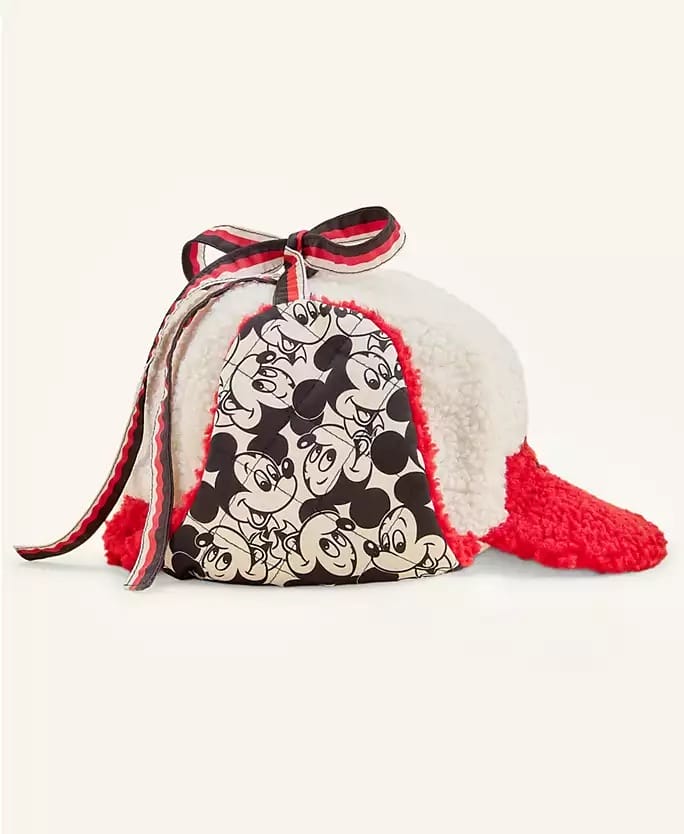 A fuzzy red and white Disney Holiday hat, topped with a striped bow and a Mickey Mouse panel, perfect for park festivities.