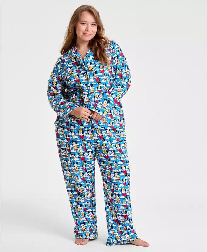 Woman in colorful blue Disney 2025 Holiday Collection pajamas stands barefoot, reminiscent of cozy Disney Parks hotel mornings.