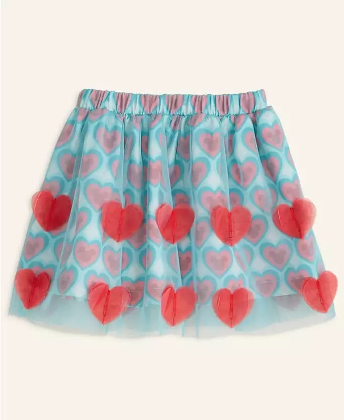 Blue tulle skirt with pink hearts and red 3D accents, styled for Macy’s Holiday Collection, reminiscent of Disney park fashion.