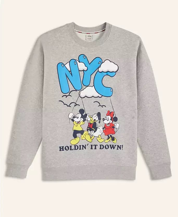 A grey sweatshirt featuring cartoon Disney characters from the 2025 Holiday Collection, as seen in Walt Disney Parks worldwide.