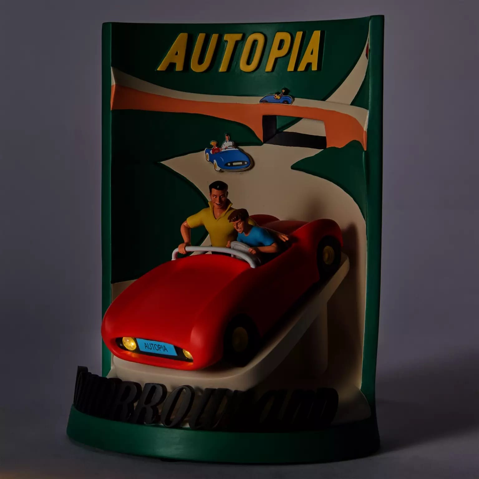 A stylized Autopia sign with two figures riding in a red car, reminiscent of Disneyland’s classic Tomorrowland attraction.