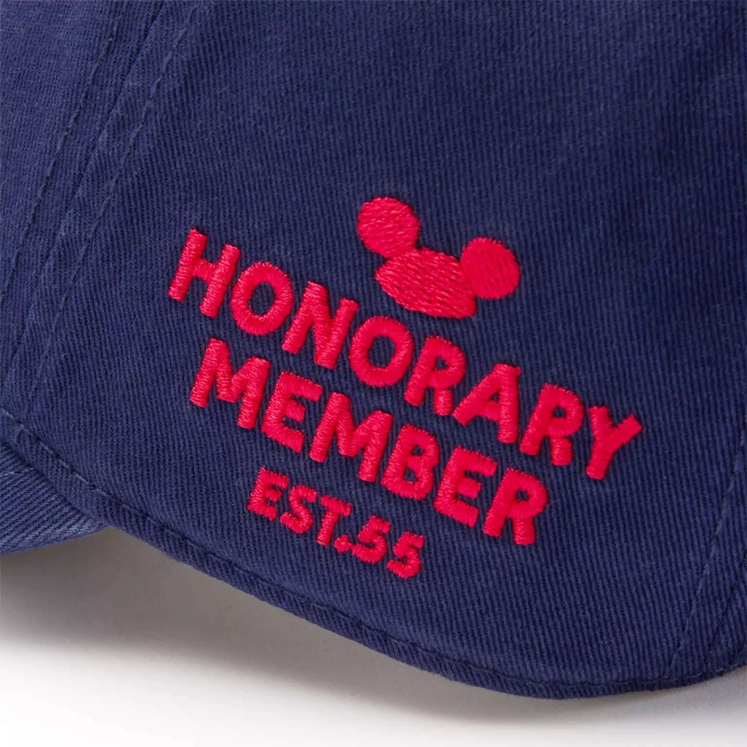 Close-up of a blue cap from the Disney Store with red embroidery and a Mickey Mouse Club head icon.