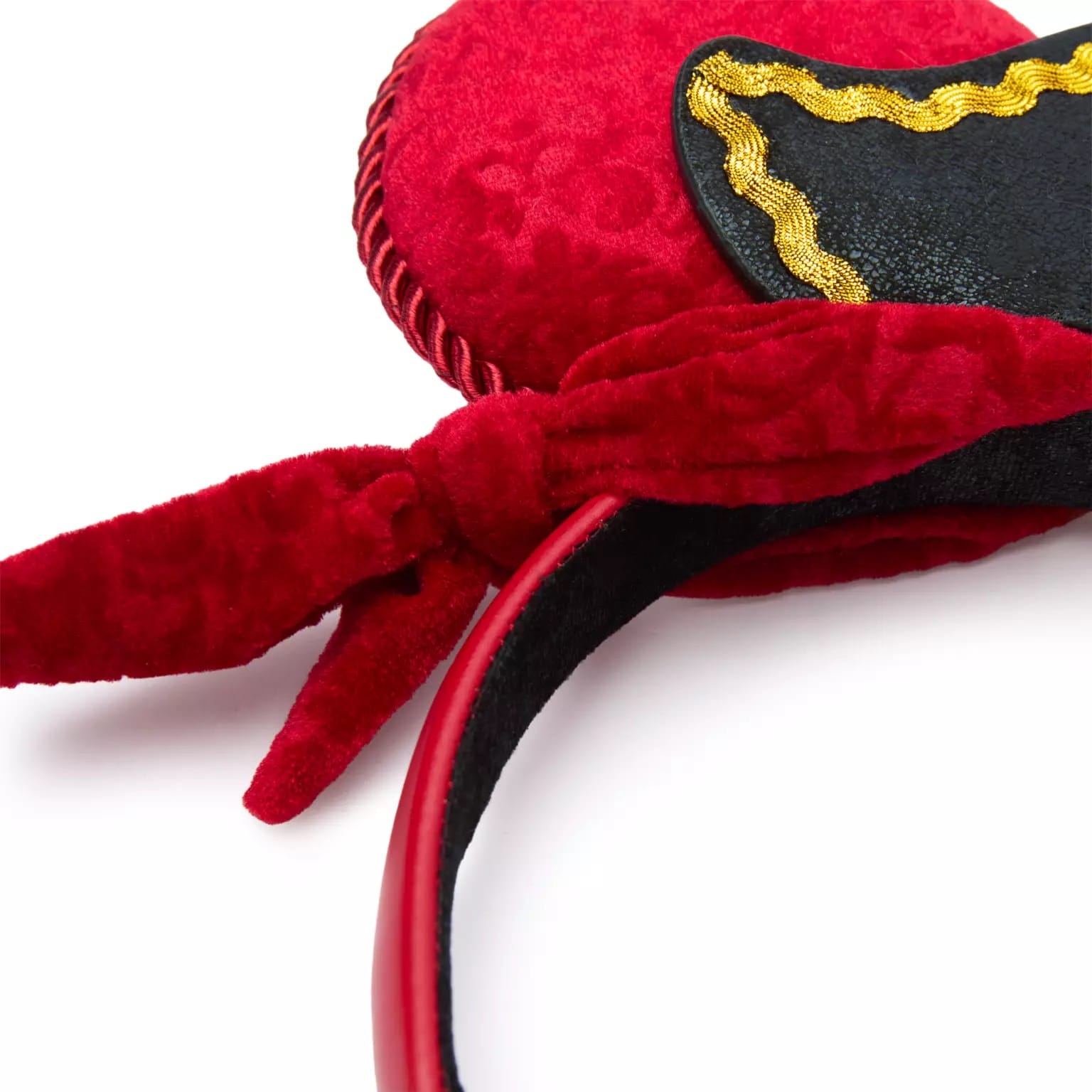 A red velvet Disney Parks ear headband with a heart shape, black accent, and gold trim, reminiscent of magical castle elegance.