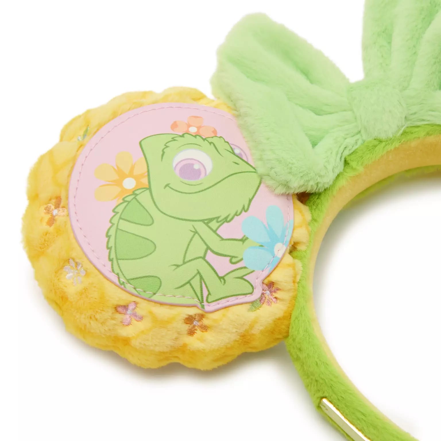 Yellow plush Loungefly ears at Disney Parks, topped with pastel Pascal, flowers, and a big green bow; no castle background shown.