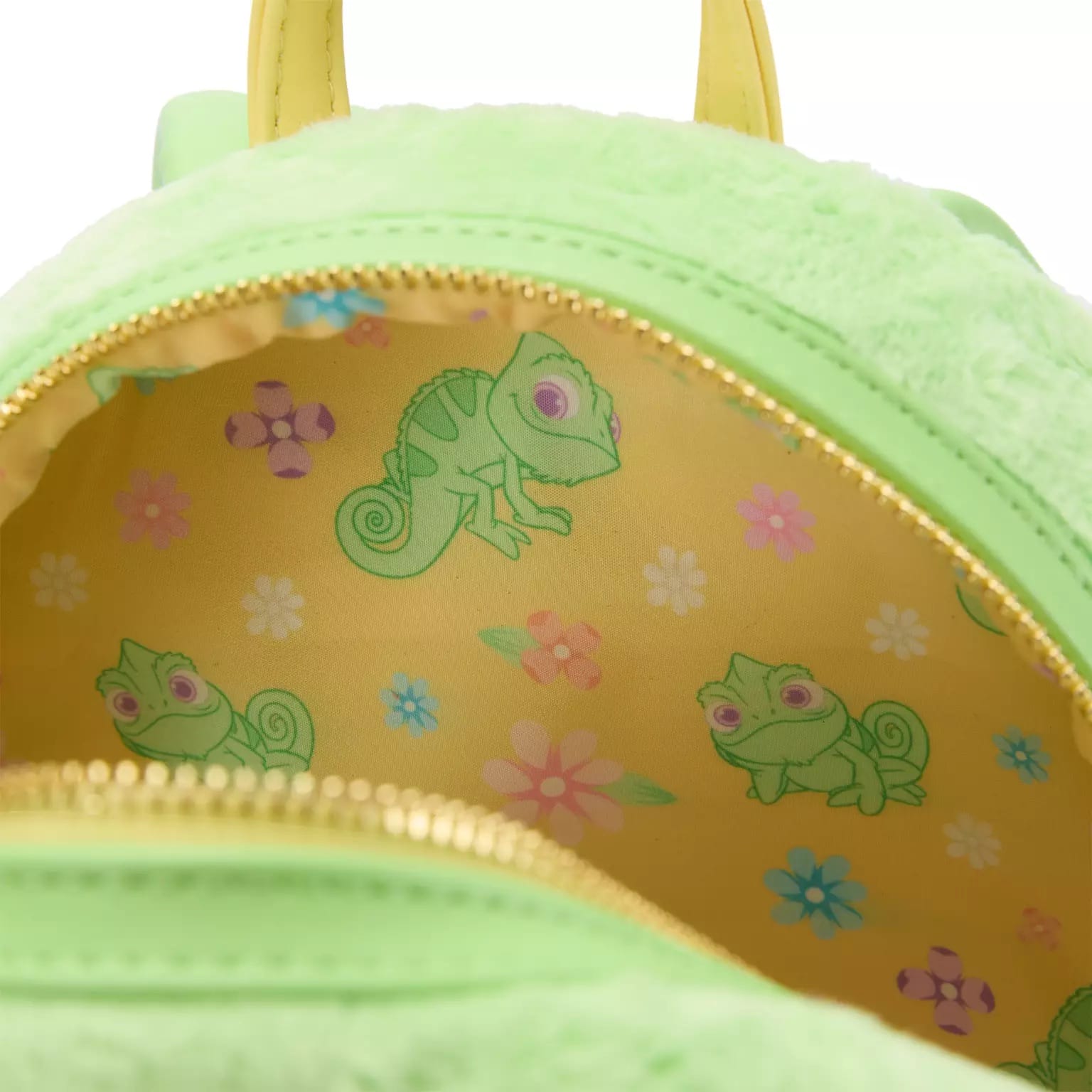 The inside of this Disney Mini Backpack is lined with yellow fabric, chameleons, and pastel flowers—like a magical park detail.