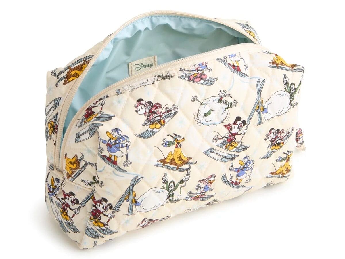 A Vera Bradley quilted pouch featuring Mickey & Friends surfing and skiing, light blue lining, and zip closure—no castle motif.