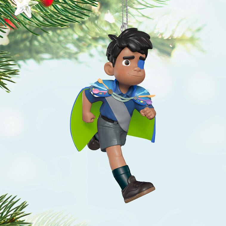 Animated boy with dark hair, cape, and eye patch hangs on tree—a Hallmark Disney Keepsake Ornament, reminiscent of park decor.