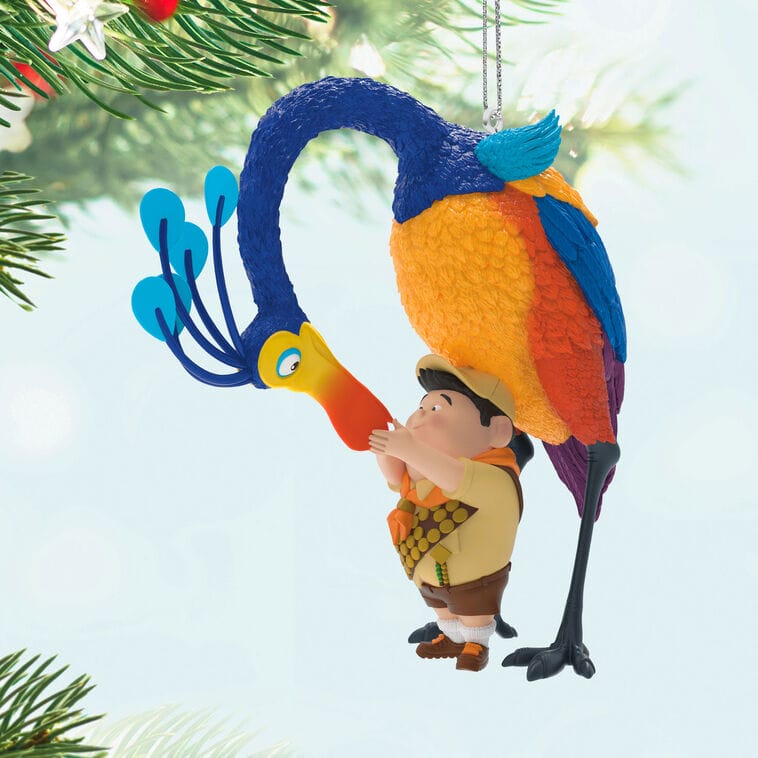 Hallmark Disney Keepsake Ornament of an explorer boy hugging a colorful bird, hanging on a tree—park magic for your holiday.