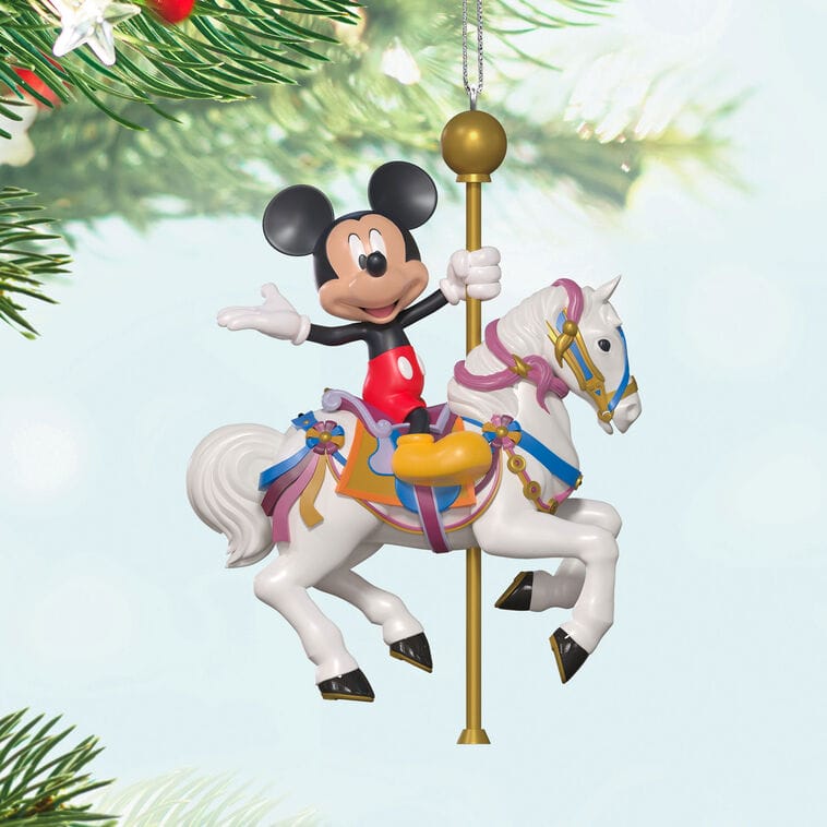 Mickey Mouse rides a carousel horse in this Hallmark Disney Keepsake Ornament, displayed on a green Christmas tree, evoking the charm of Disney park carousels near iconic castles.