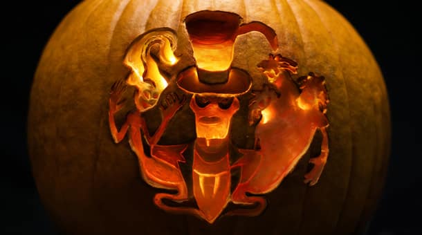 A glowing Disney pumpkin carved with three ghostly figures evokes Halloween magic, reminiscent of park decorations worldwide.