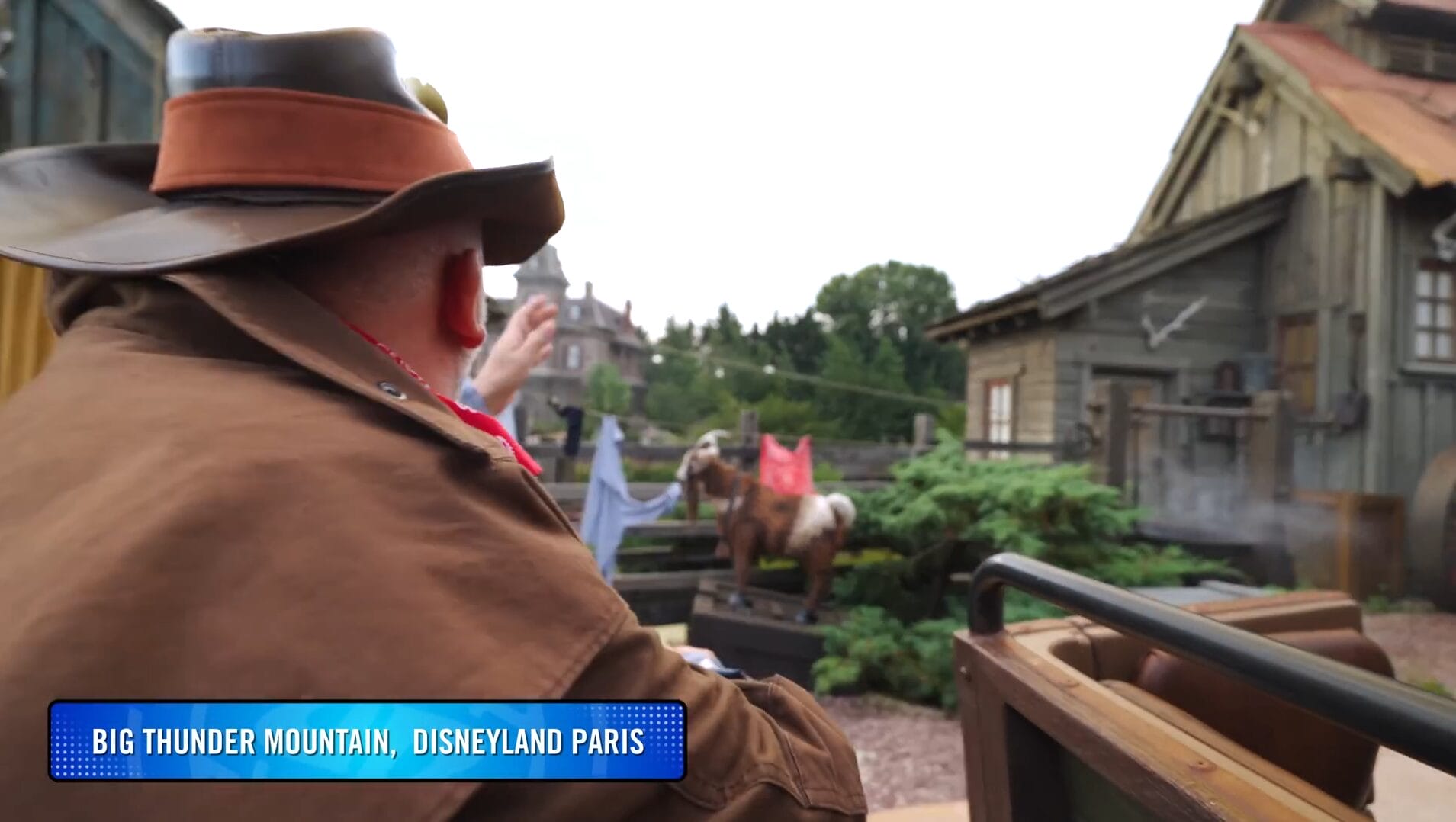 A person in a cowboy hat rides Big Thunder Mountain at Disney Park, passing western props in this thrilling VIDEO.