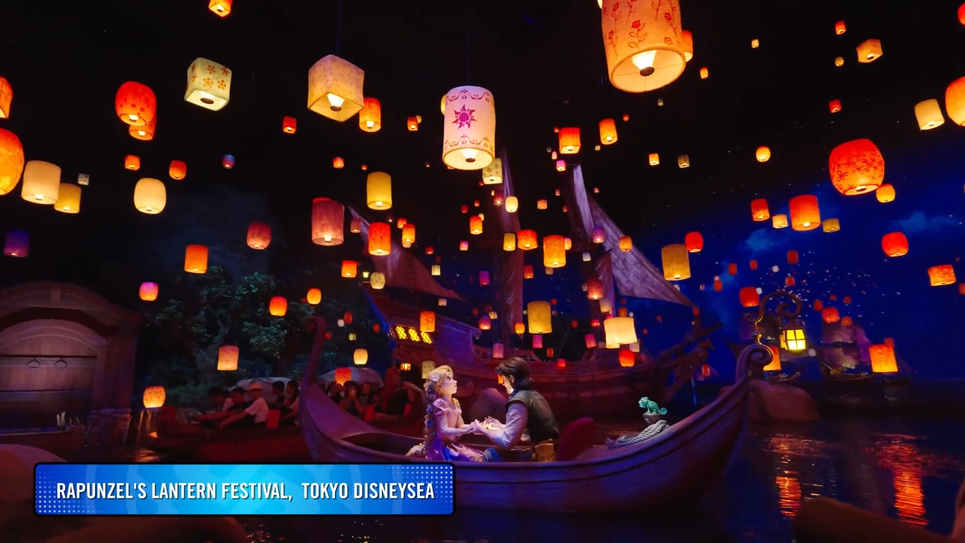 Rapunzel and Flynn sit in a boat surrounded by floating lanterns at Disney Park's magical festival attraction.