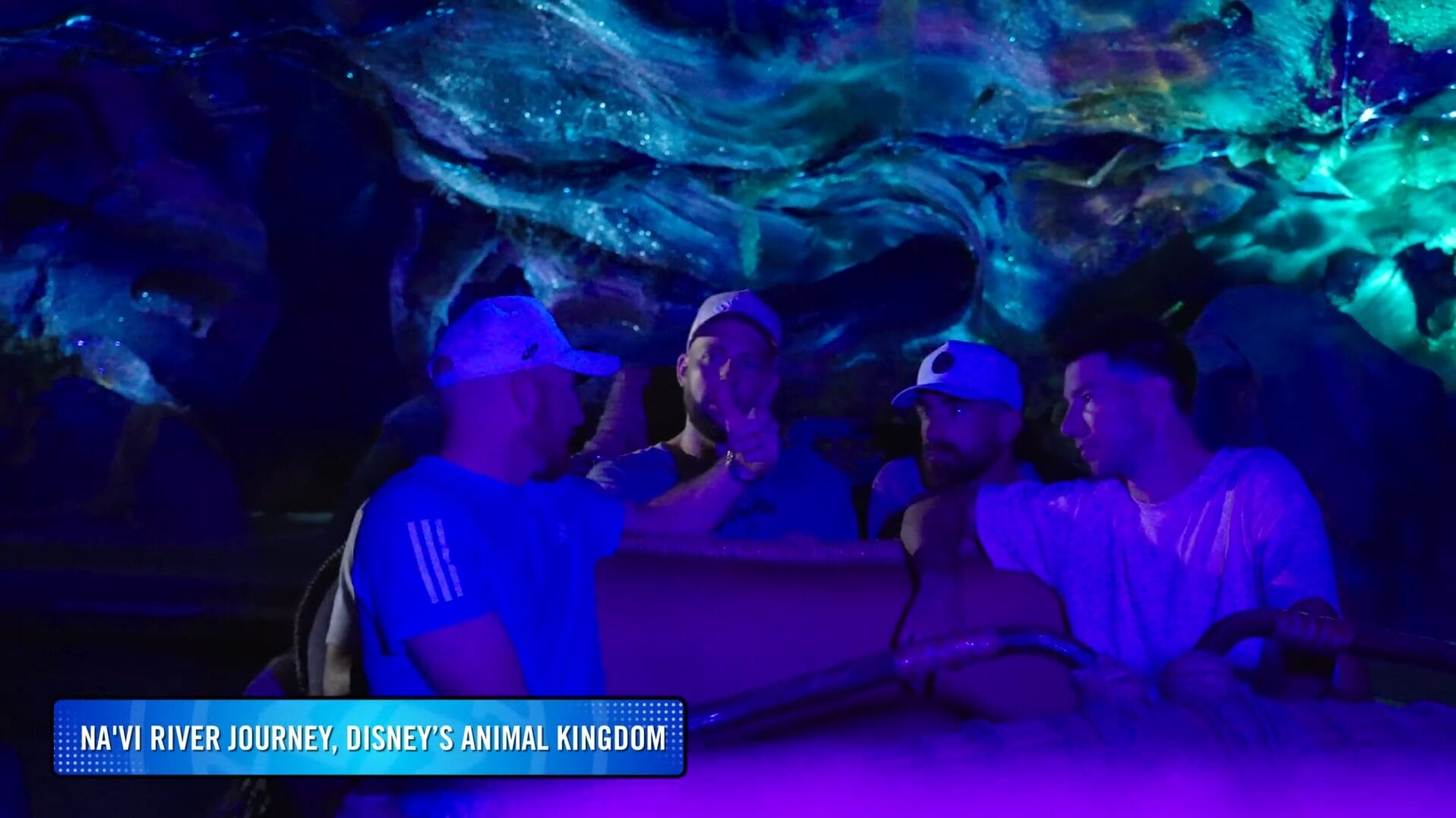 Five people on Na’vi River Journey at Disney Park, surrounded by glowing blue scenery.