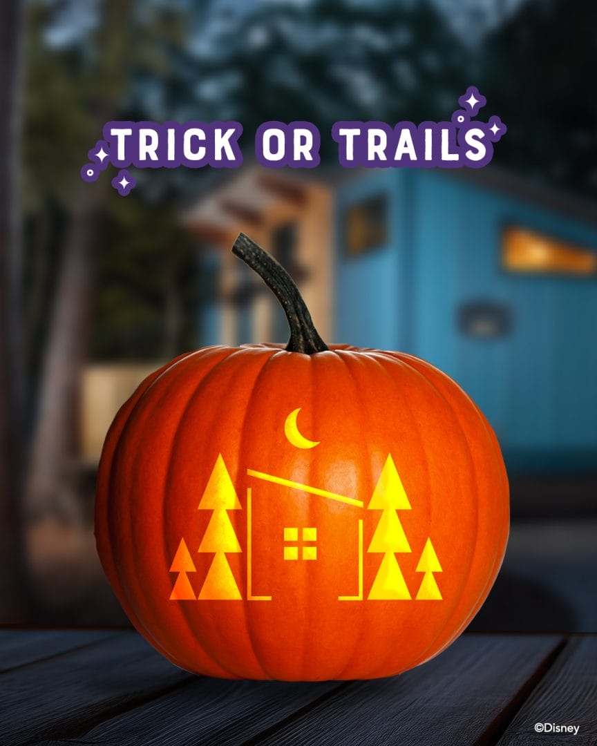 A pumpkin carved with trees, a house, and a crescent moon in a Disney Park style; "Trick or Trails" above, like park décor.