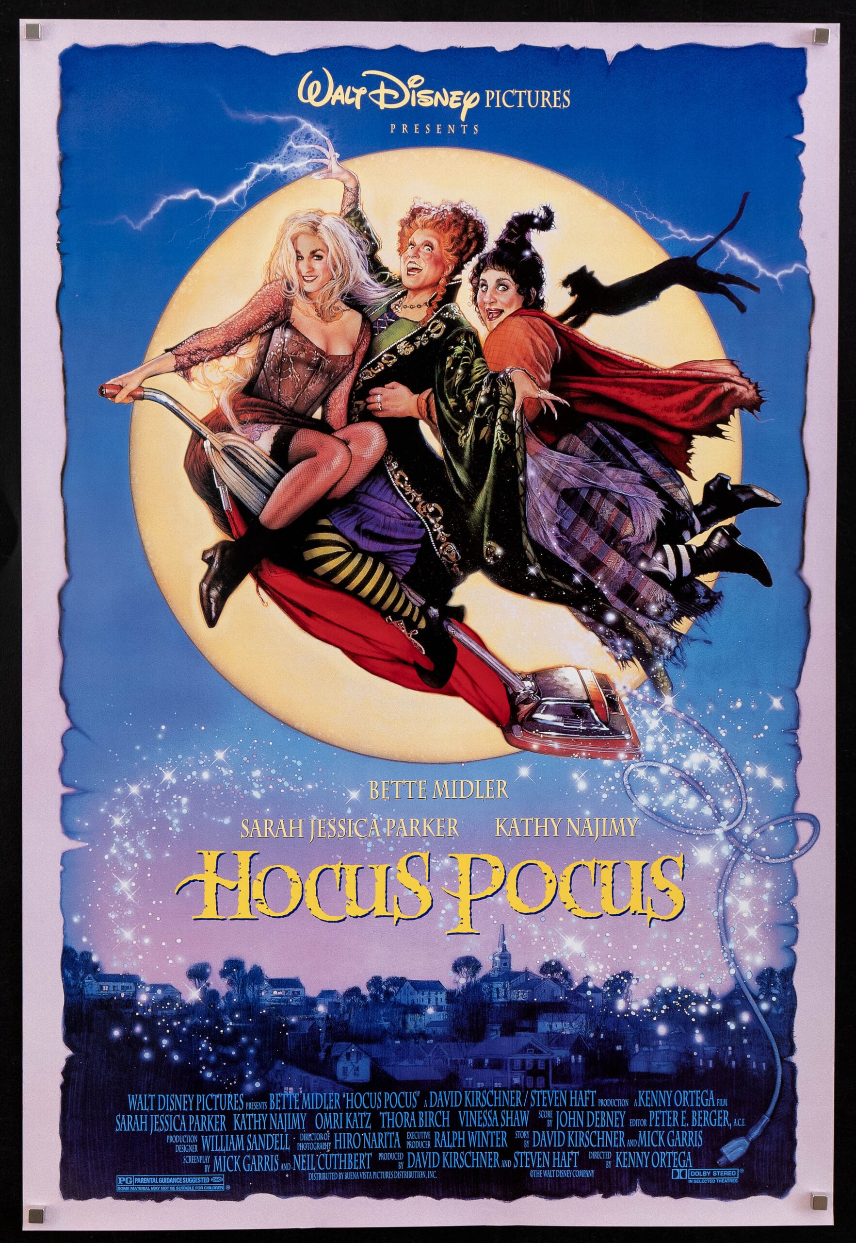 Three witches fly on a broomstick above a spooky town, resembling a Disney Halloween night, but no Disney castle is visible.