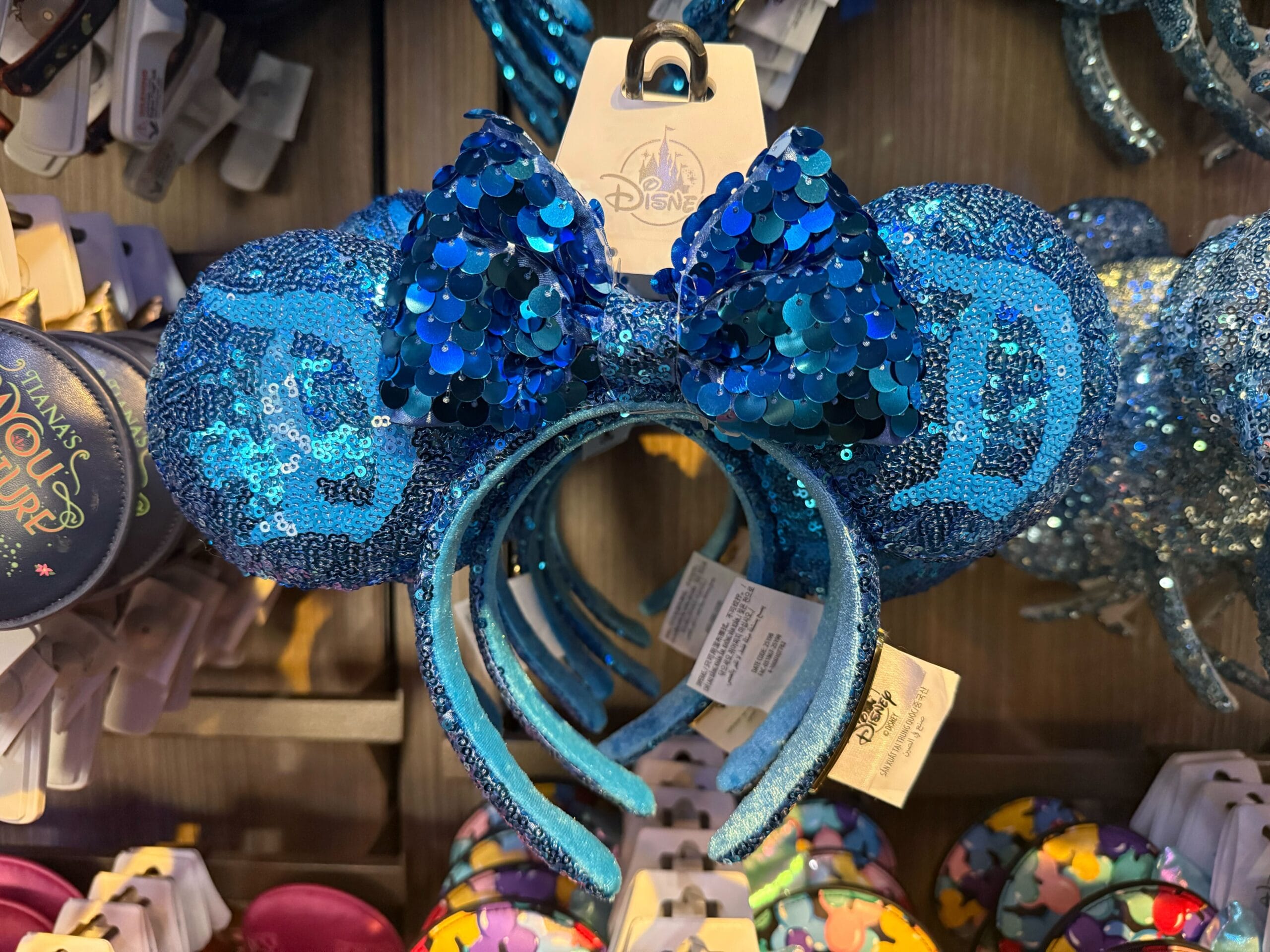 Blue sequined Mickey Mouse ears with a sparkly bow, ideal for Disney Park visits—from Anaheim to Paris, just like Cinderella Castle.