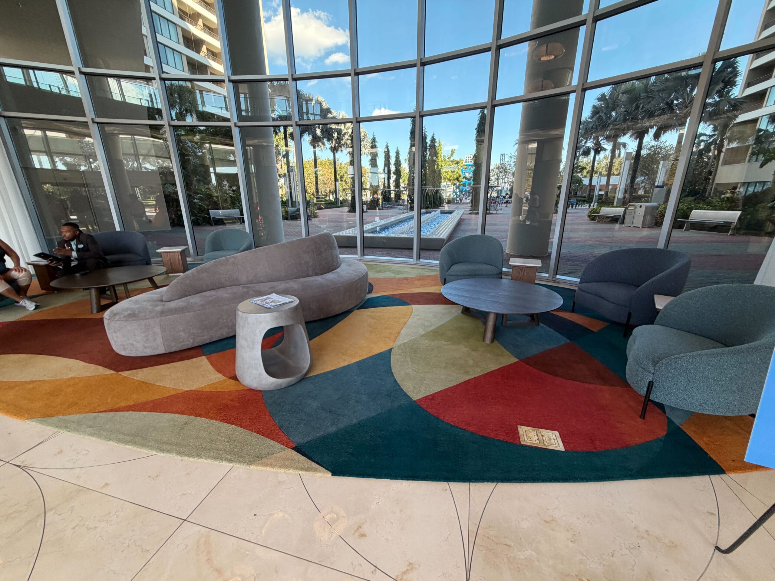 Sleek Contemporary Resort lobby with curved sofas, round tables, and Bay Lake Tower views—quintessential Disney resort elegance.