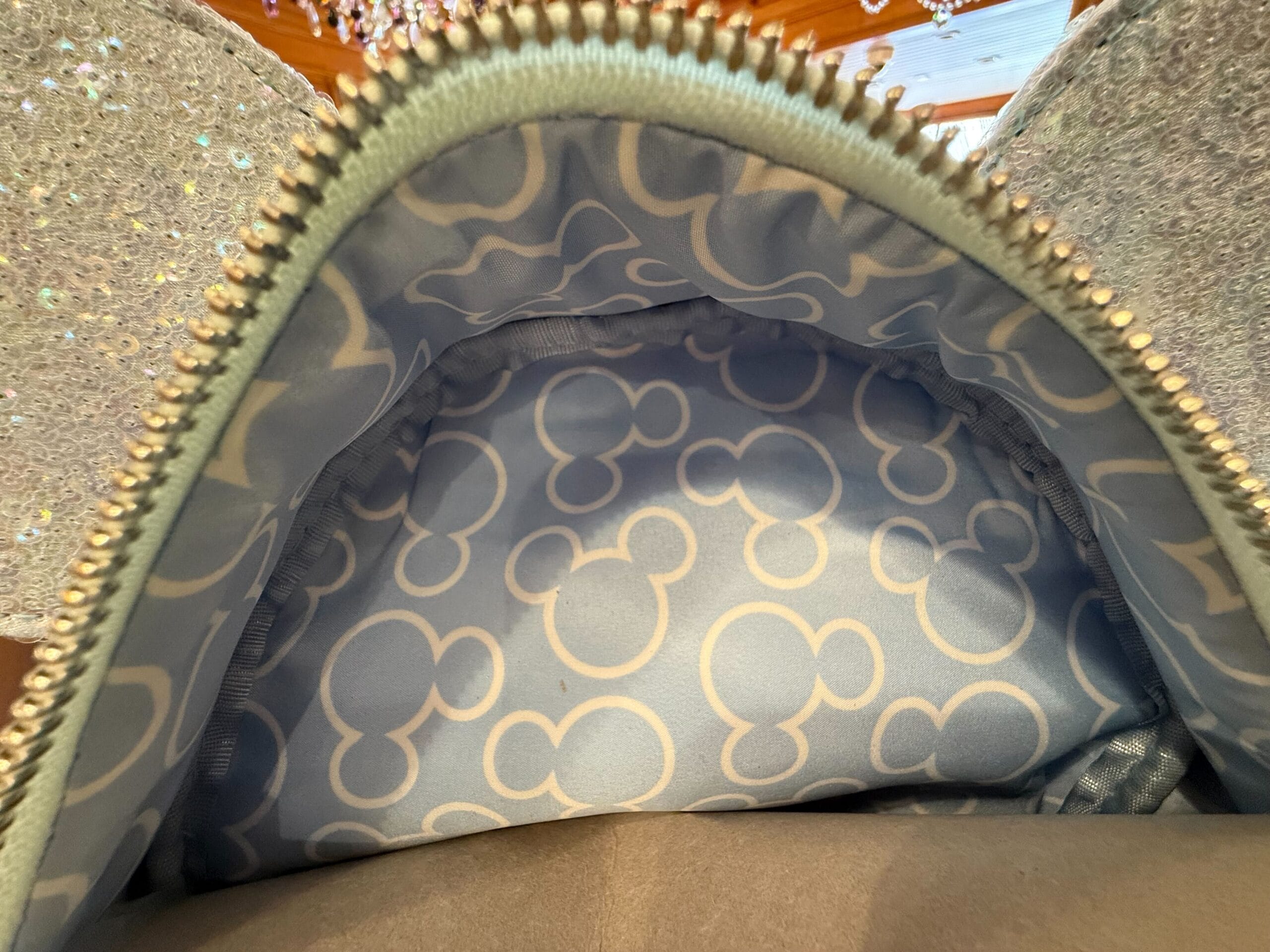 Open zipper shows Winter Blue Loungefly Backpack lining with white Mickey Mouse head silhouettes, a nod to classic Disney Parks style.