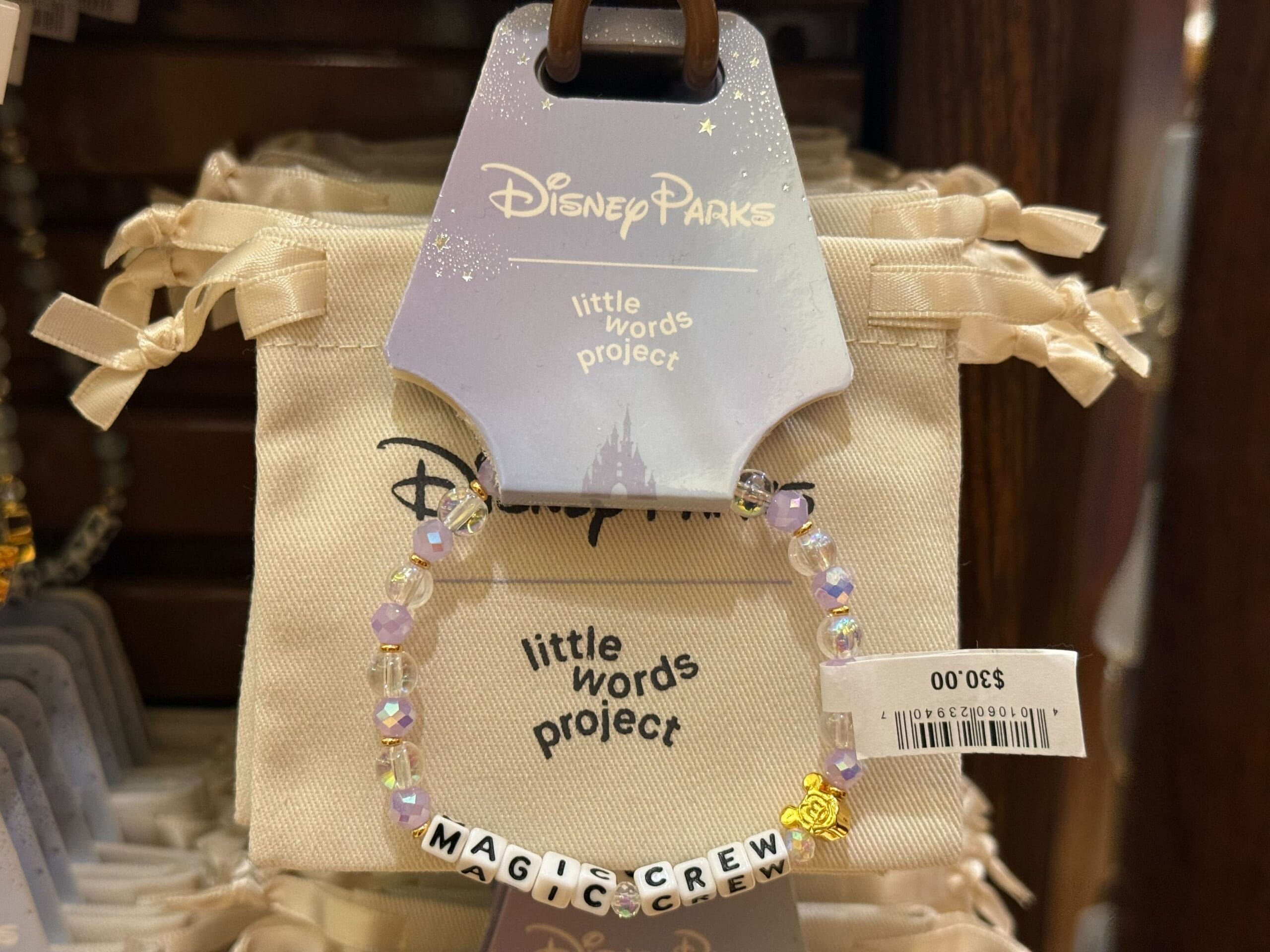 Beaded "MAGIC CREW" bracelet with Mickey charm on a Disney Parks card; evokes the magic unique to all Disney castle parks.