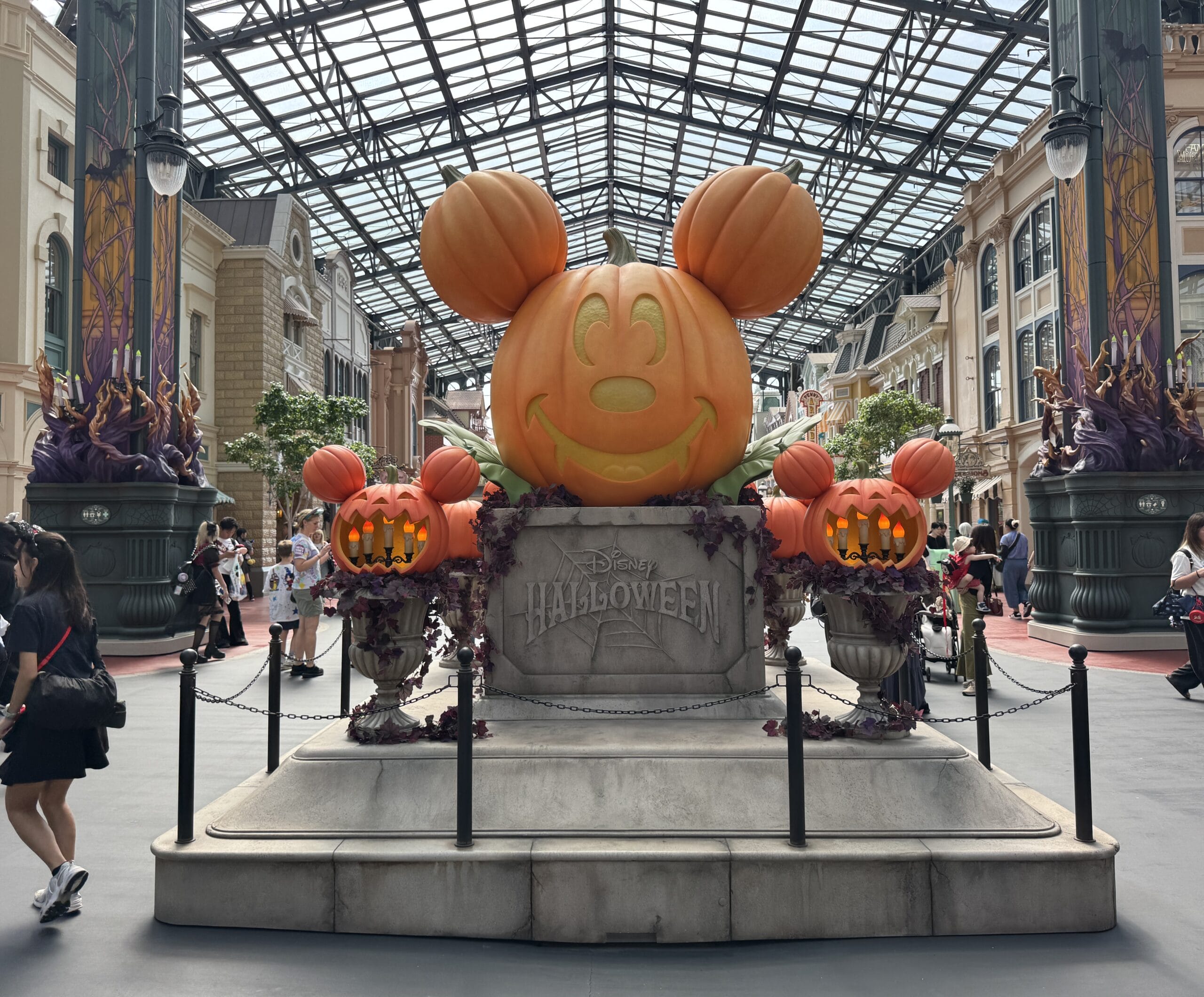 Mickey Mouse pumpkin statue with "Disney Halloween" sign at Tokyo Disney Resort, surrounded by indoor festive pumpkins—no castle shown.