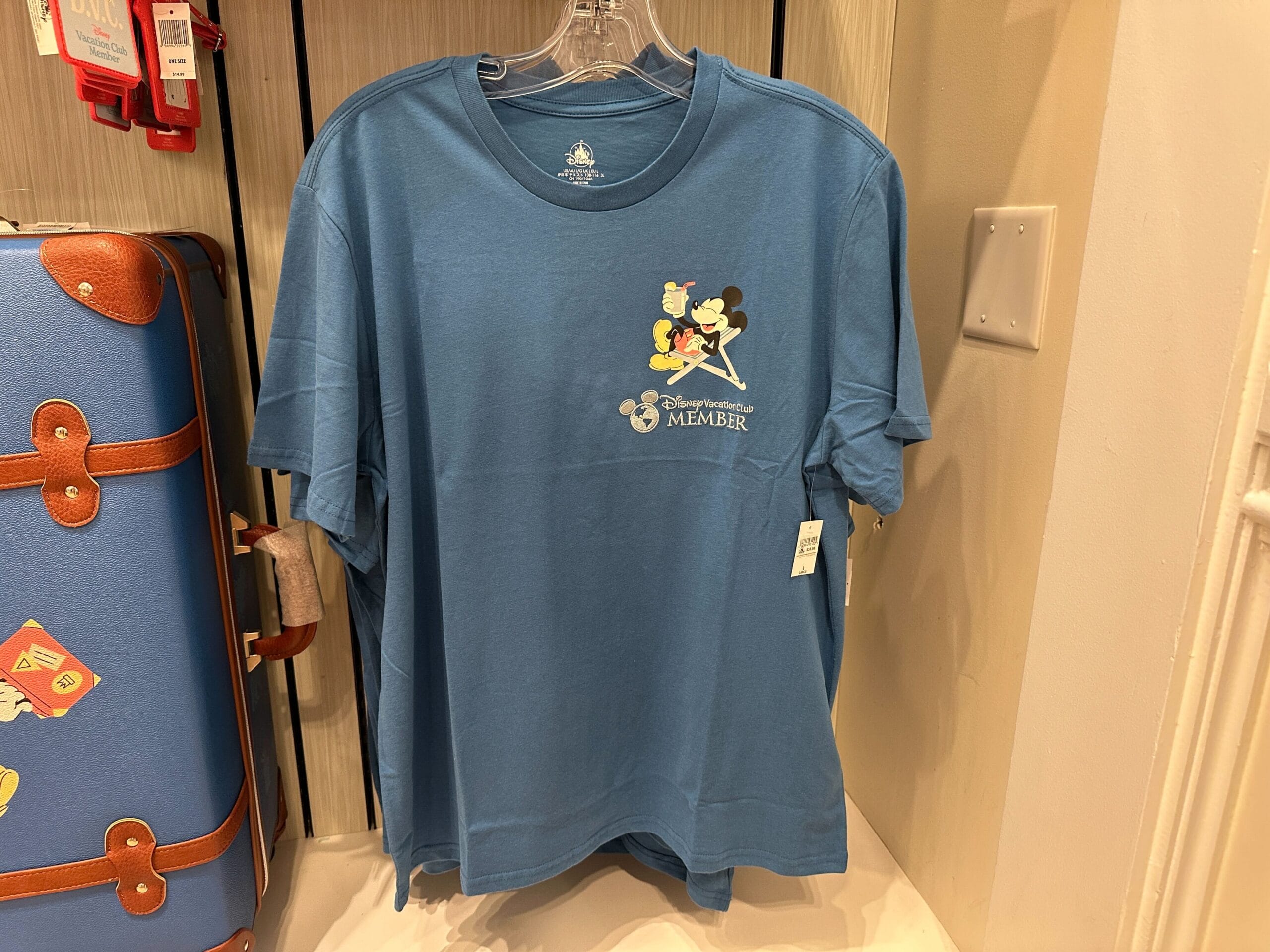 Blue T-shirt with Mickey Mouse on a beach chair and “Disney Vacation Club Member” text.