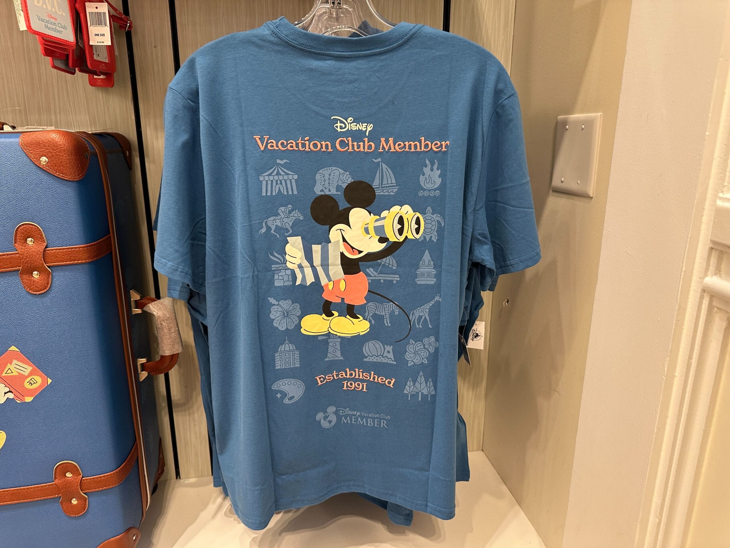 Blue Disney Vacation Club Member t-shirt with Mickey Mouse and DVC Member Resort logos.