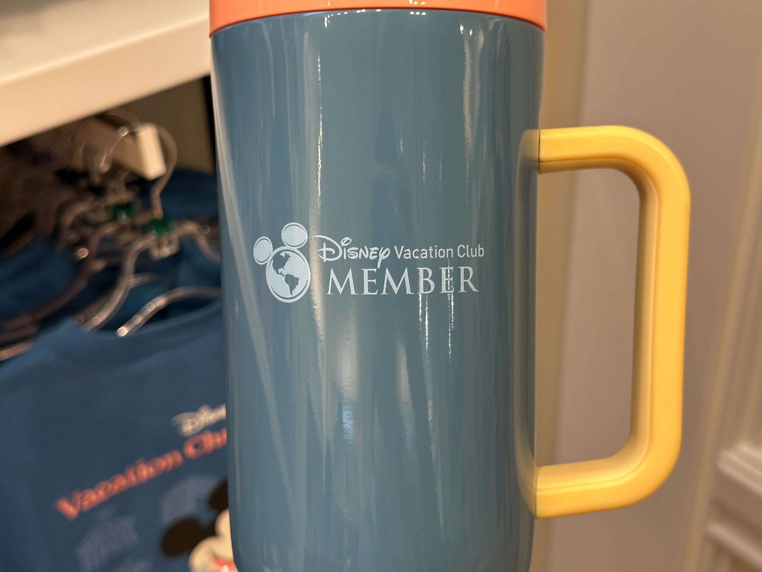Close-up of a blue travel mug from the DVC Member Merch Collection with Mickey Mouse and Grand Floridian details.