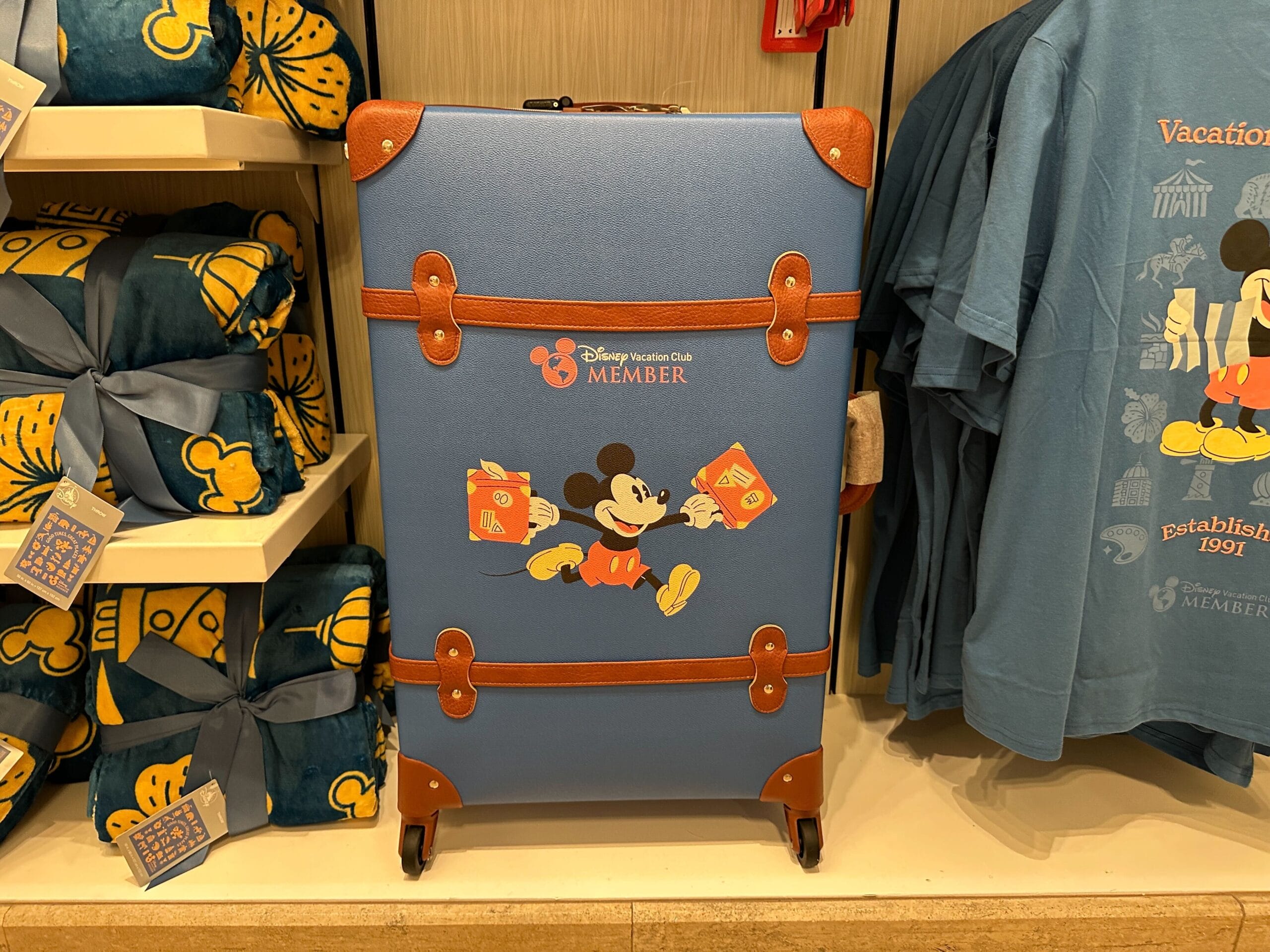 Blue suitcase with Mickey Mouse and "Disney Vacation Club Member" text, part of the Grand Floridian merch collection.