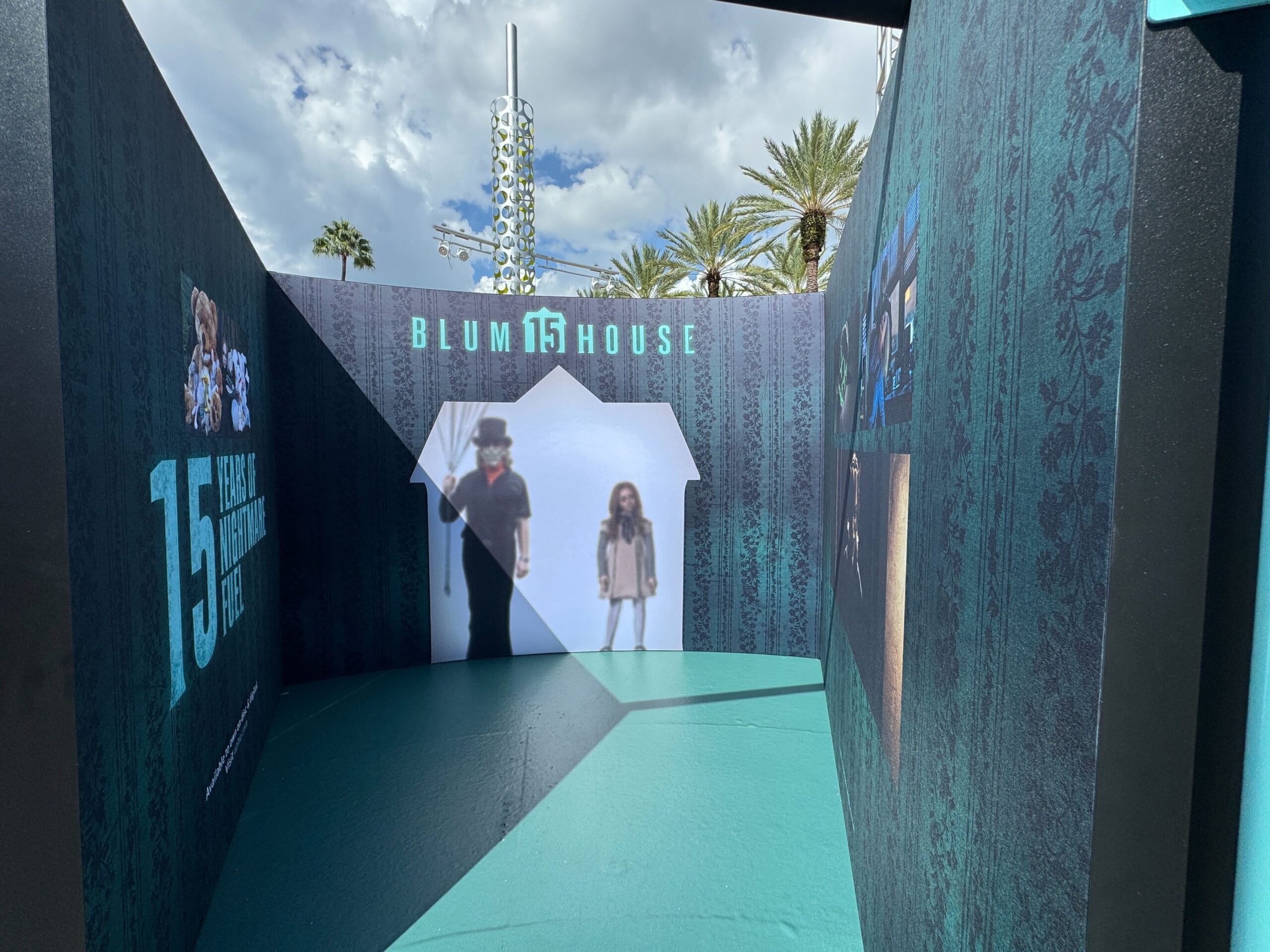 Blumhouse 15th anniversary display at Universal CityWalk with film silhouettes, images, and photo ops on teal-patterned walls.