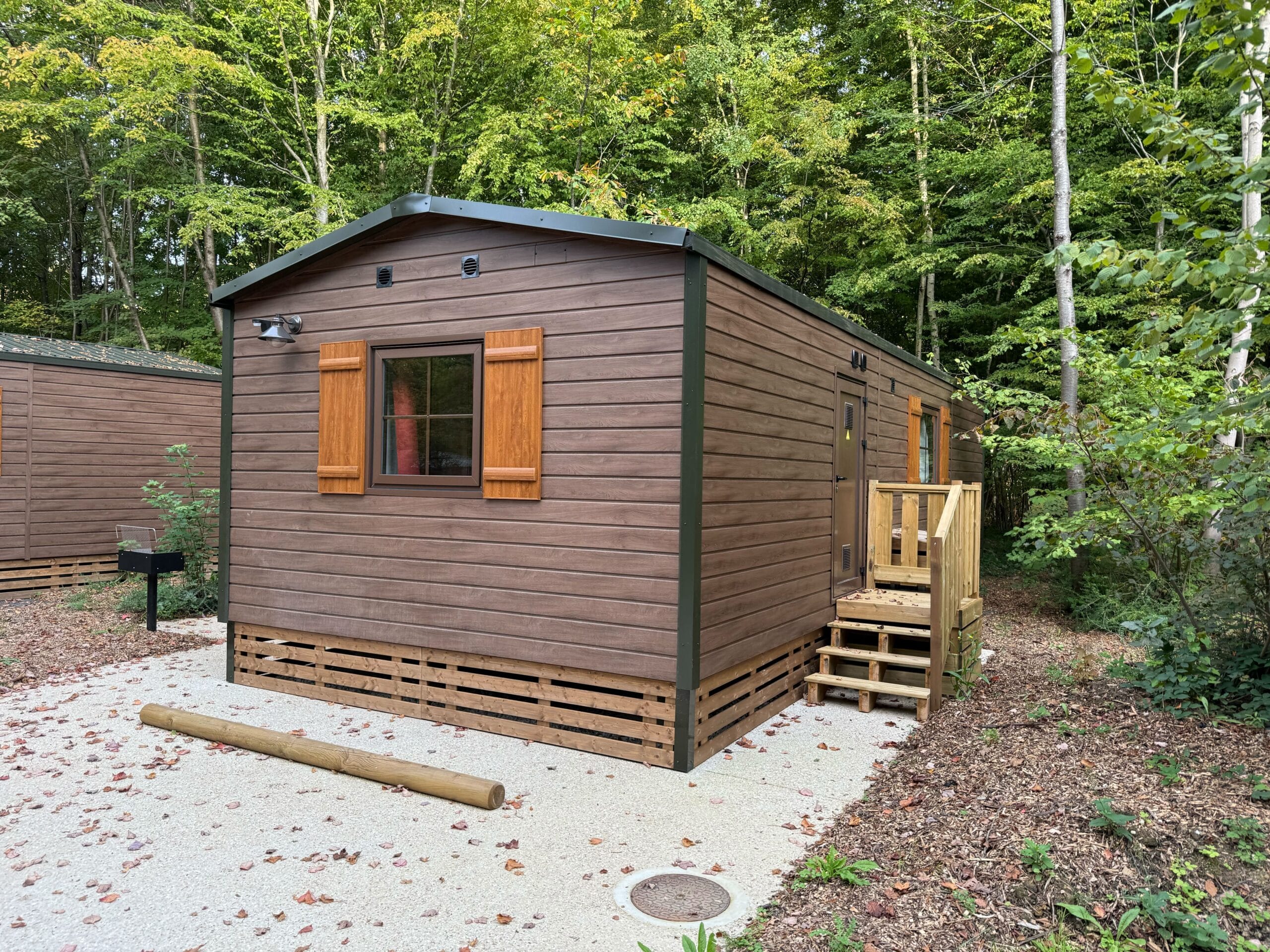 Cozy standard cabin at Davy Crockett Ranch set among lush trees, minutes from Disneyland Paris.