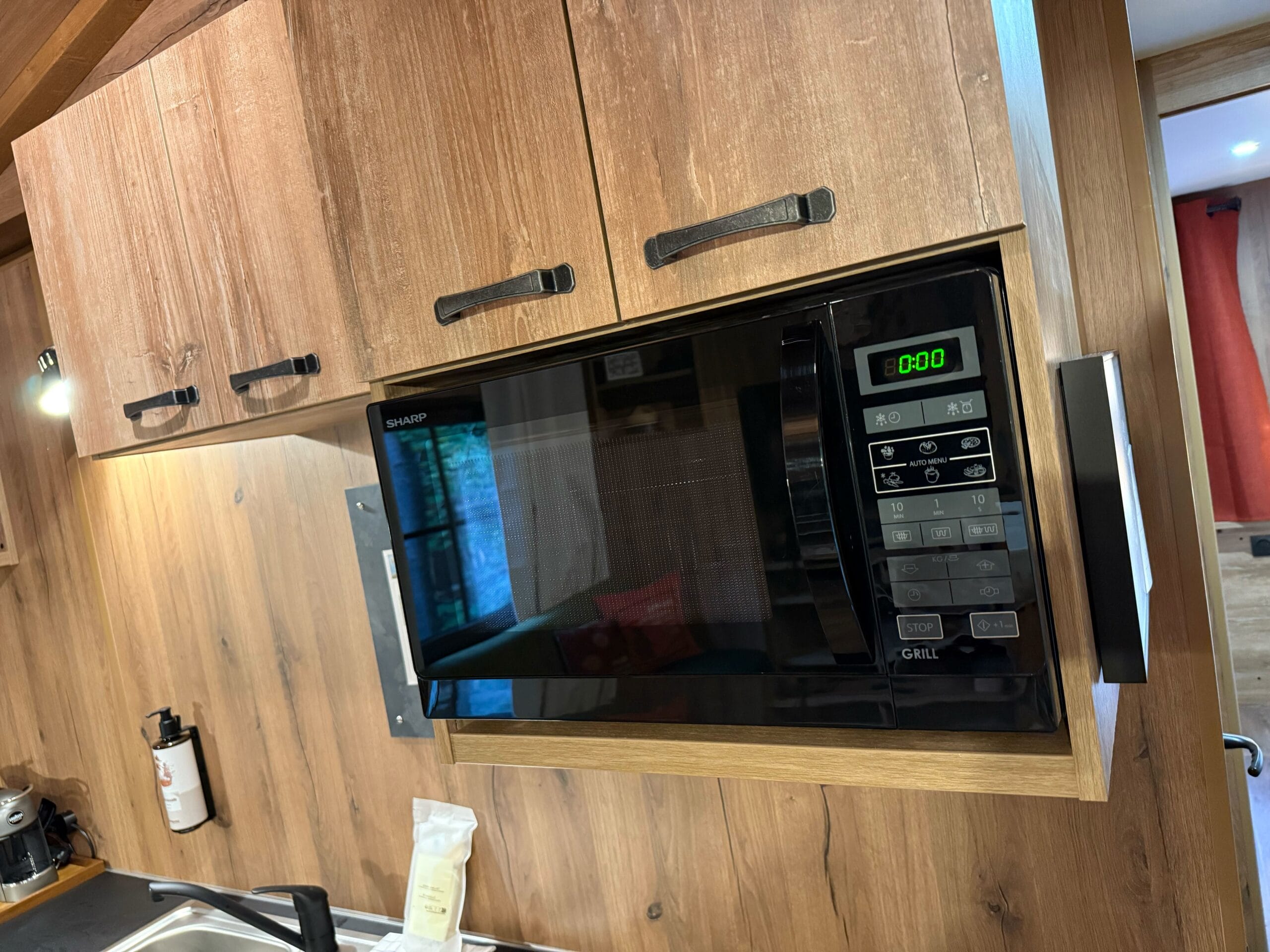 A microwave built into rustic cabinets in a cabin at Davy Crockett Ranch at Disneyland Paris.