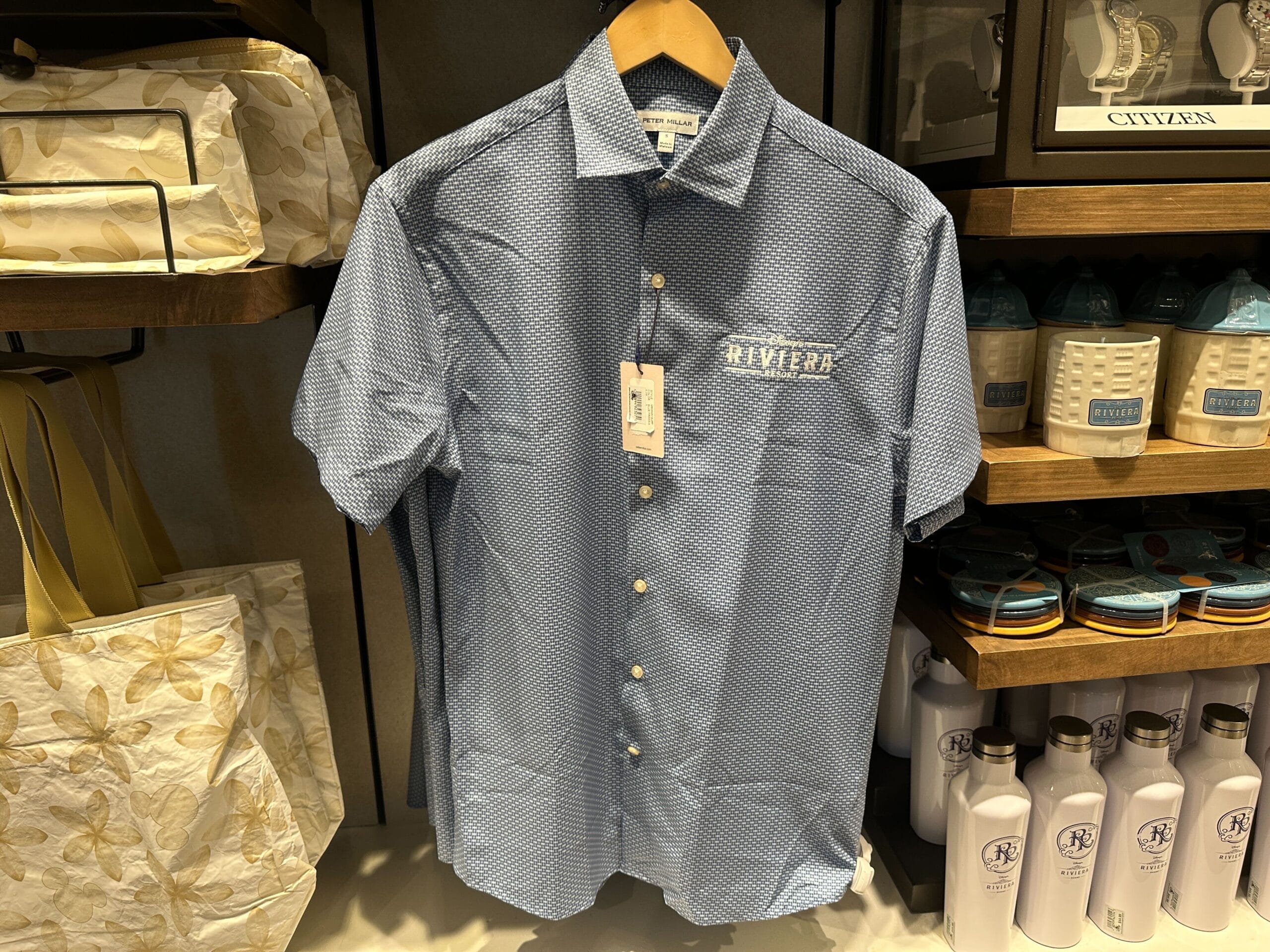 Blue short-sleeve button-up featuring "RIVIERA" logo, a new arrival at Disney's Riviera Resort shop—exclusive Disney Parks merch.
