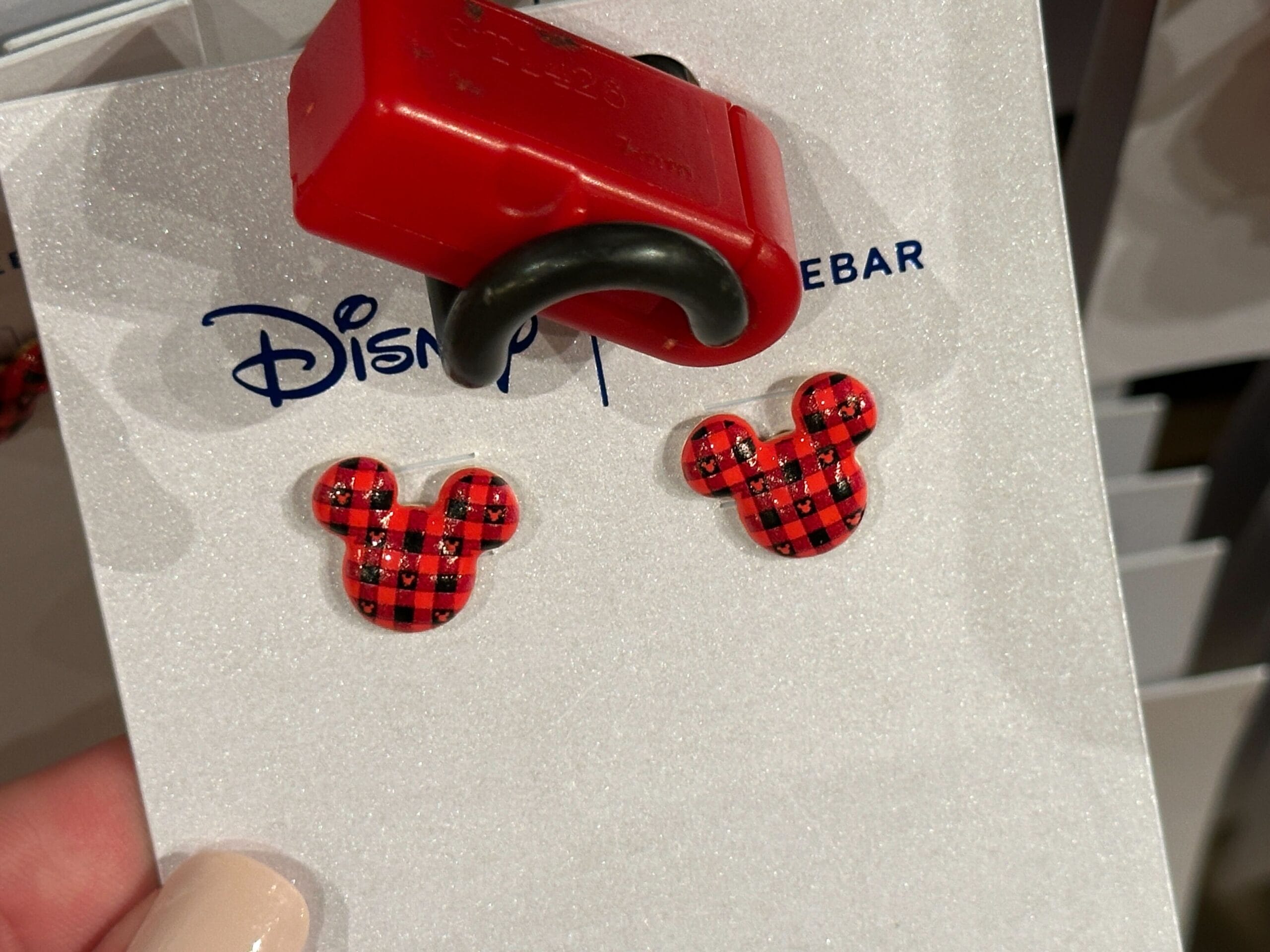 Red and black plaid Mickey Mouse stud earrings on a Disney card—cheerful Christmas gift, seen at Walt Disney World 2025.