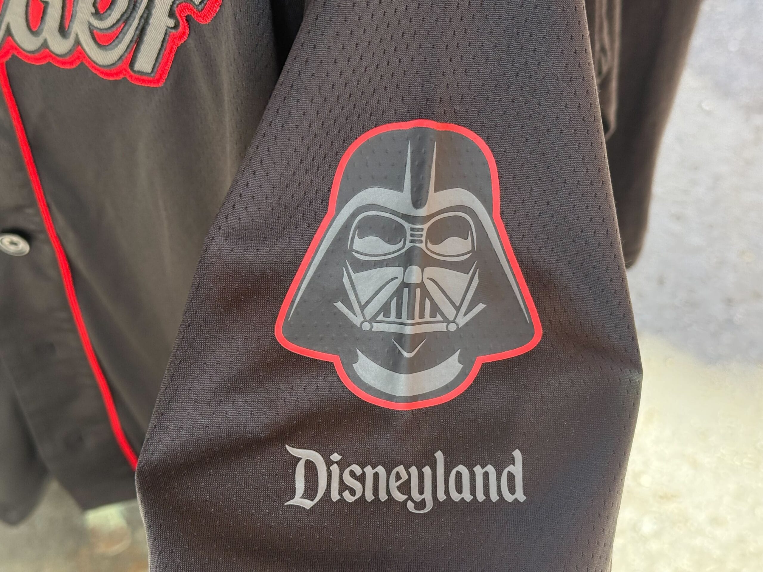 A black sleeve features Star Wars merch with a Darth Vader graphic above "Disneyland" in white Gothic-style text.